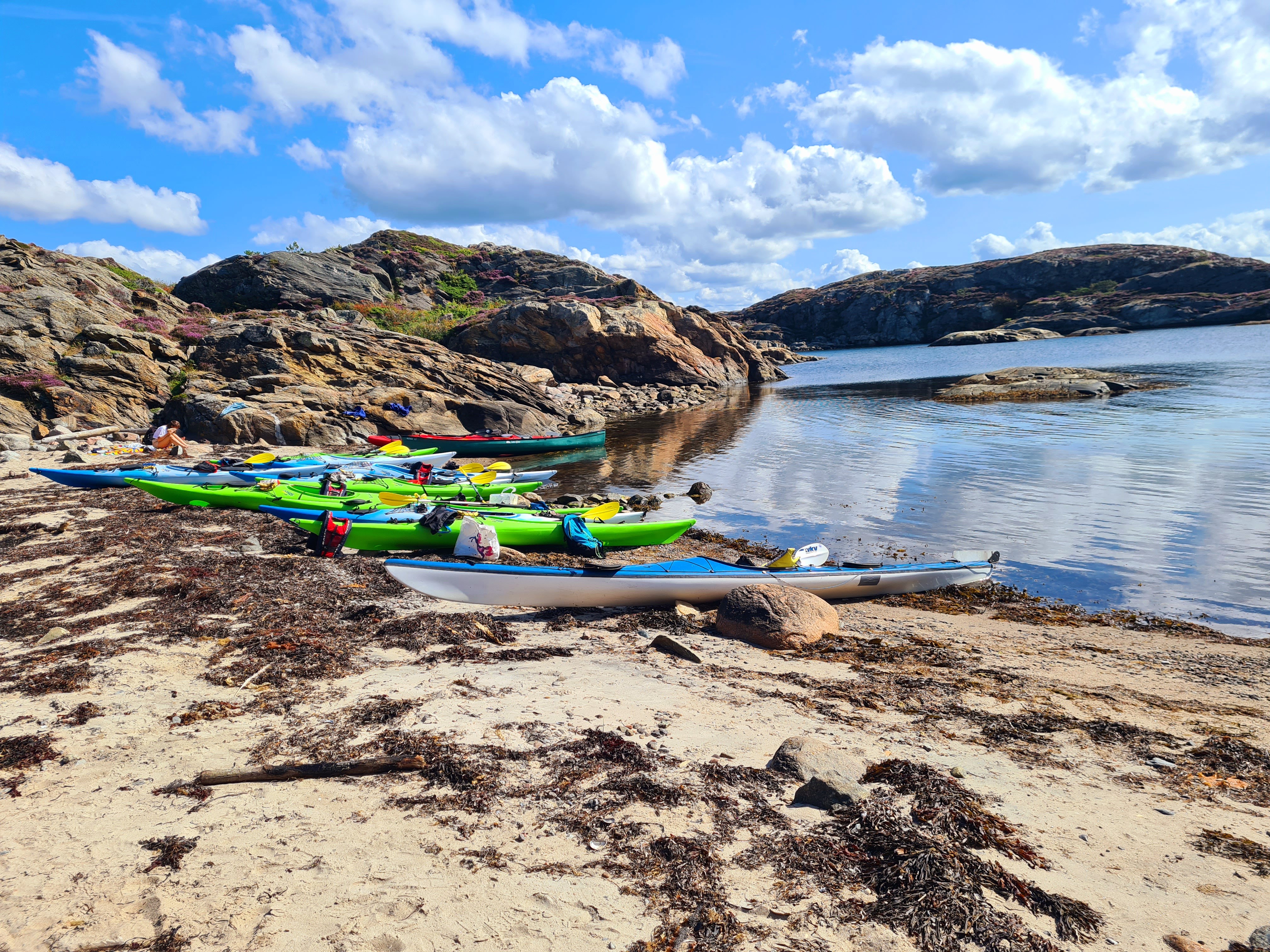 Kajaker uppdragna på en sandstrand i Bohuslän