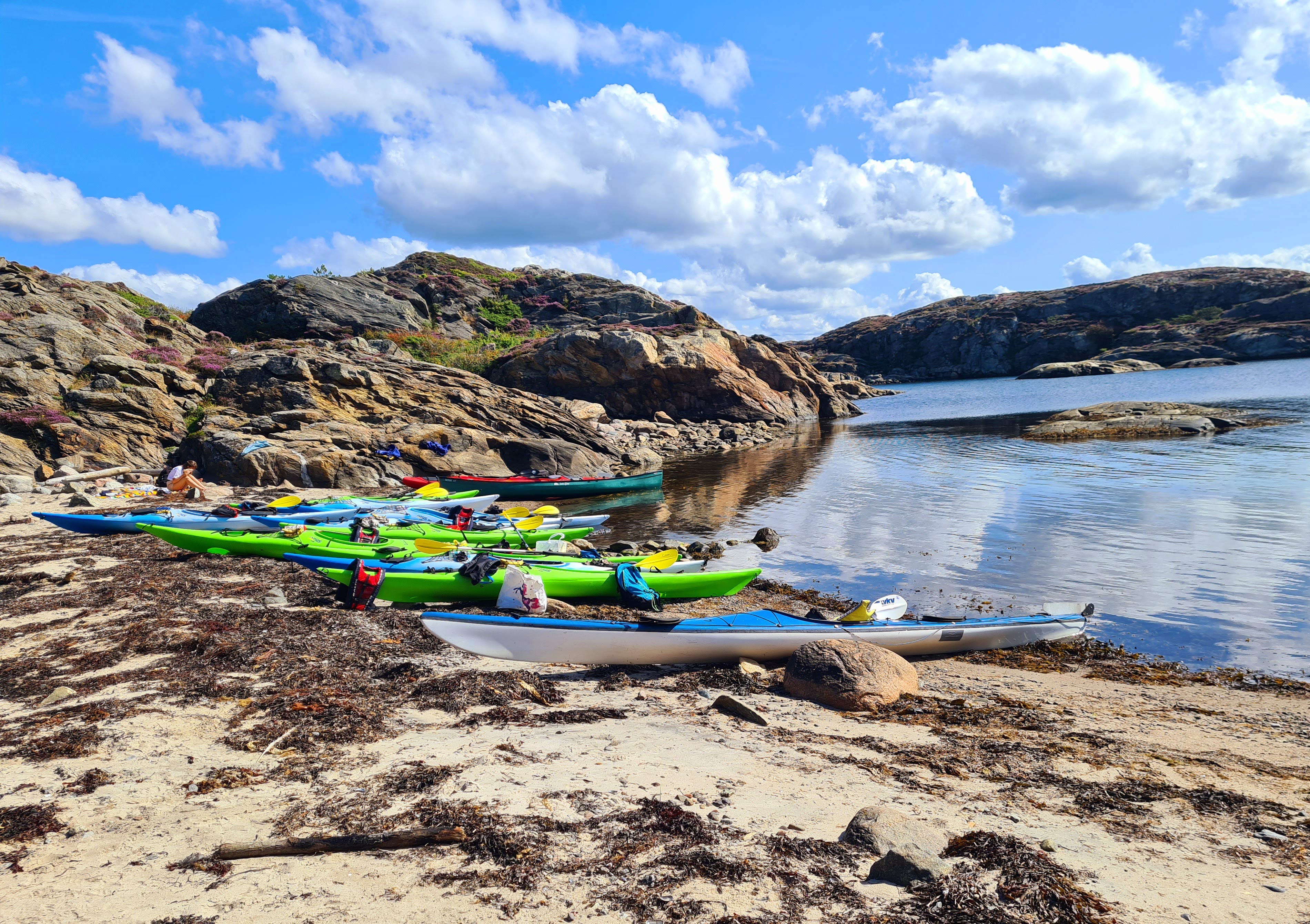 Kajaker uppdragna på en sandstrand i Bohuslän