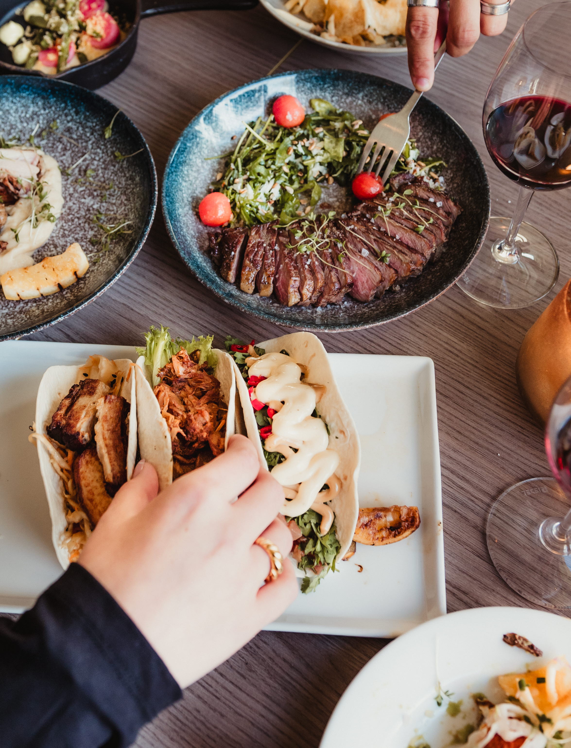 A laid dinner table with delicious dishes from the restaurant's sharing menu at Hotell Smögens Hafvsbad