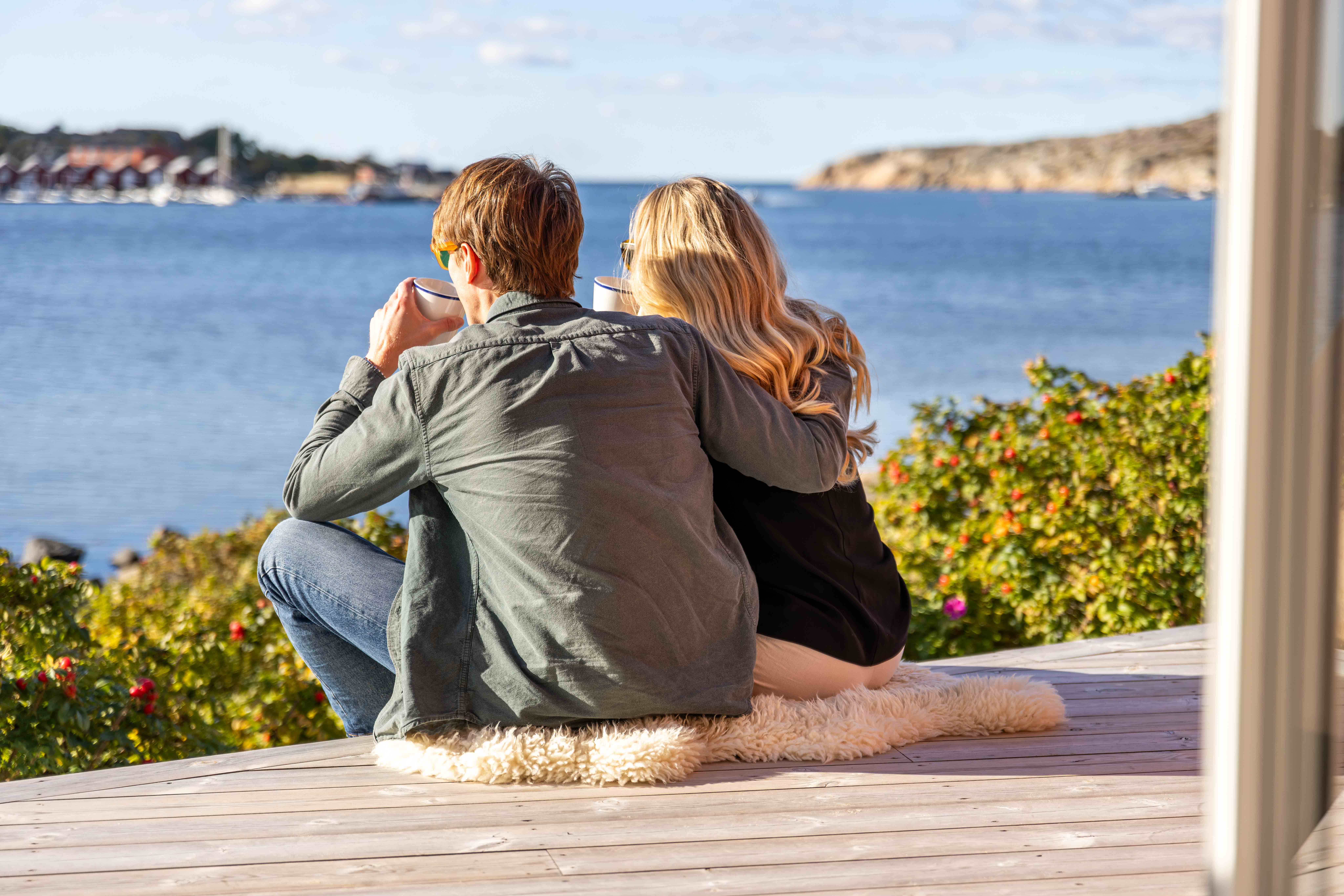 Ett ungt par fikar på terrasen med en underbar  skärgårdsvy hos Hönö Sjöbodar