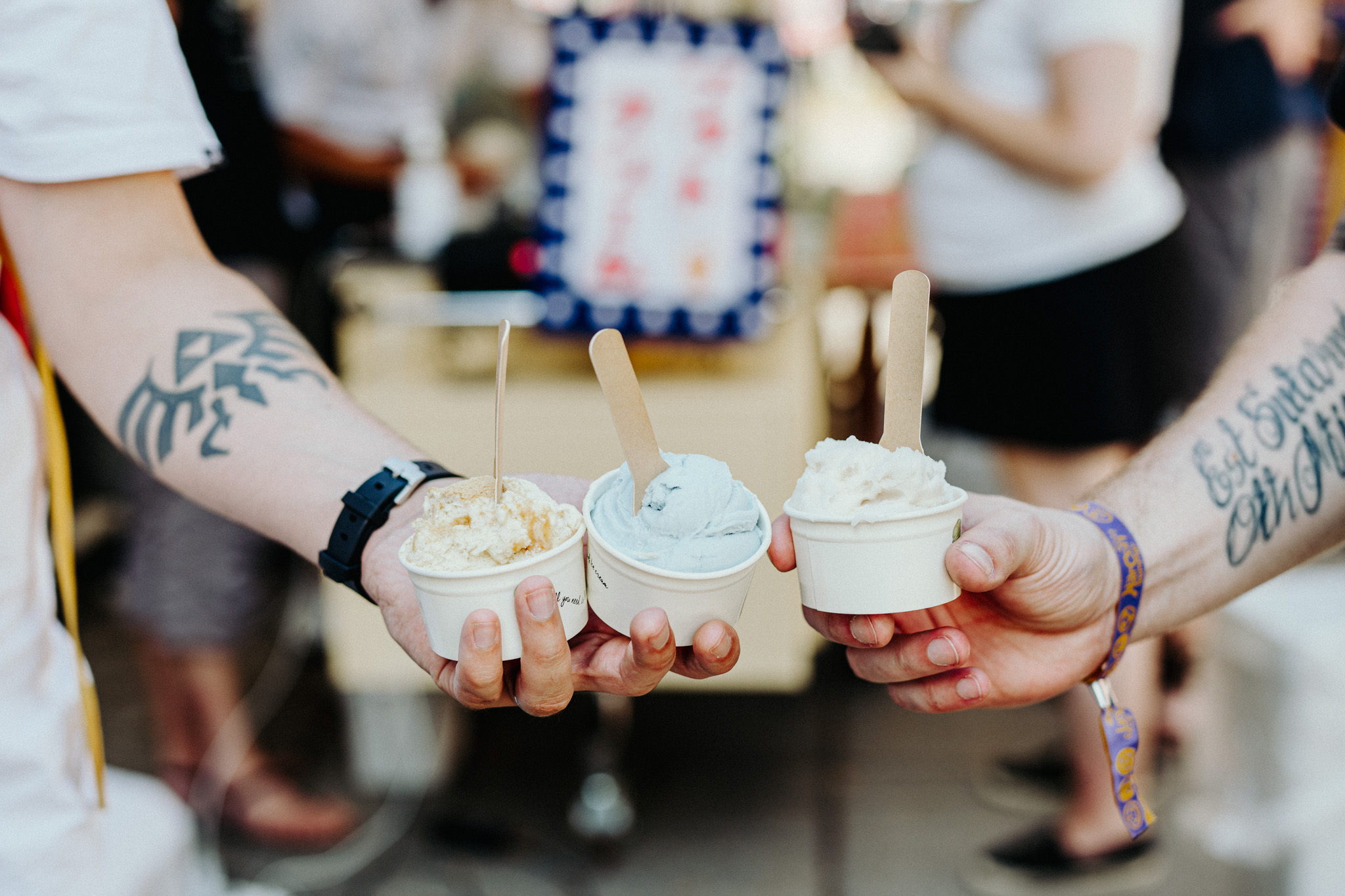 Hands holding filled ice cream cups from Hollander's ice cream