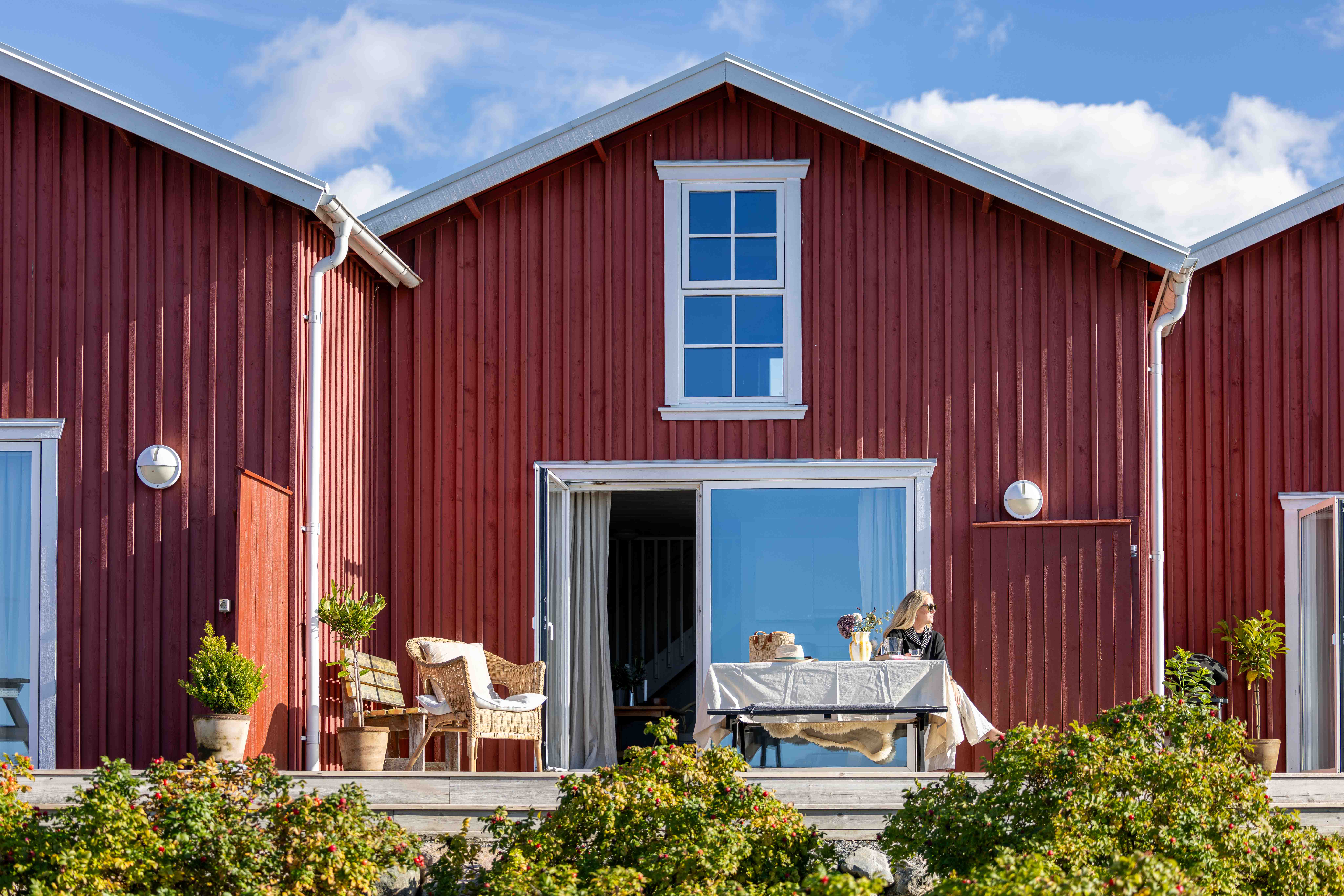 Solig terrass med bord och korgstol på Hönö Sjöbodar