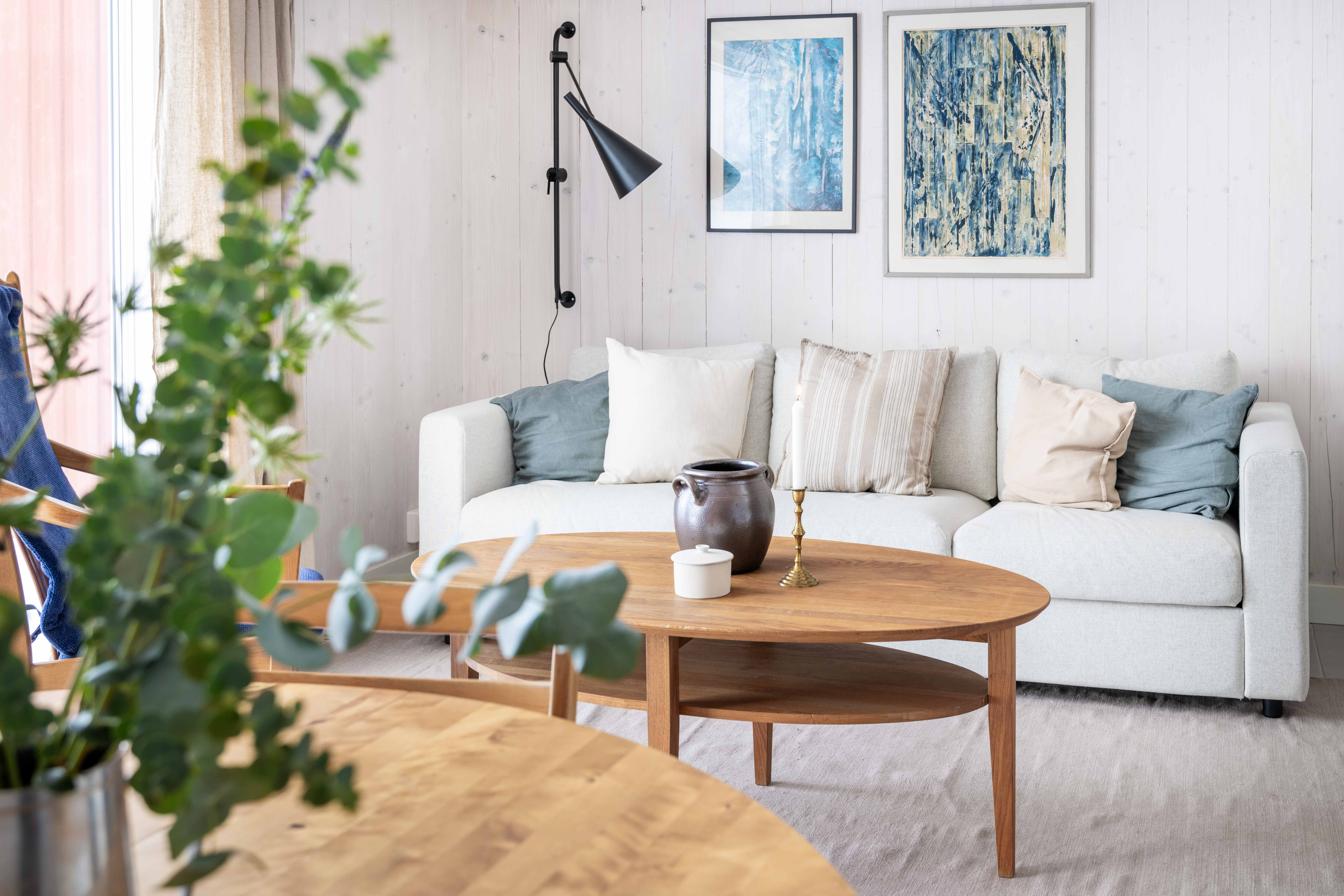 Ljus soffa med kuddar i ett mysigt rum.