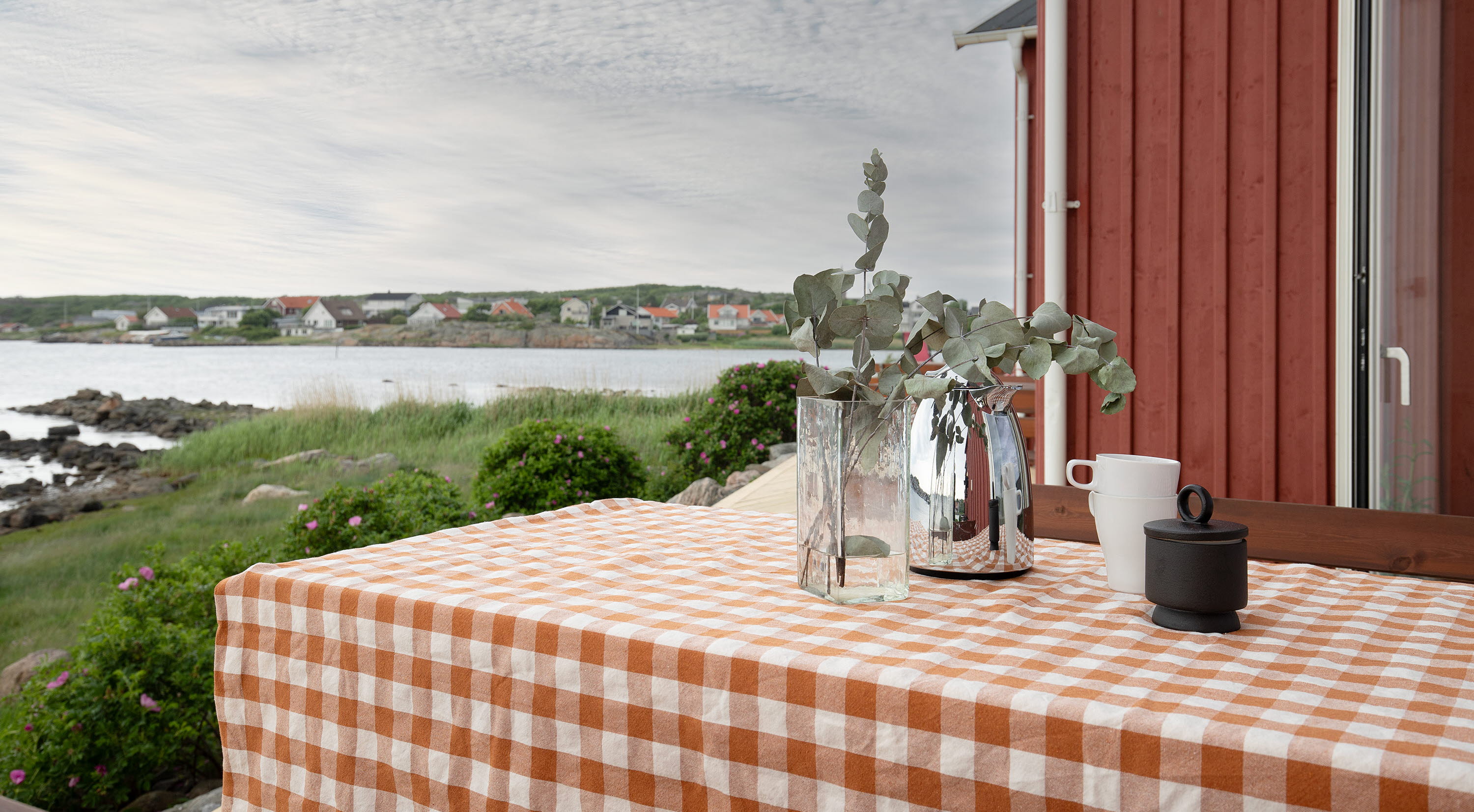 Dukat bord utomhus vid en röd trävägg.