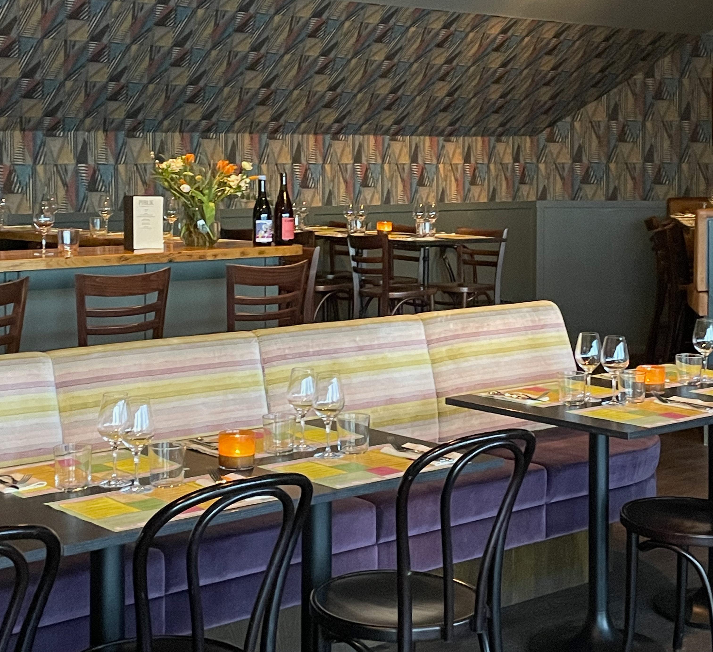 Interiörbild med bord och stolar på Publik Mat & Bar