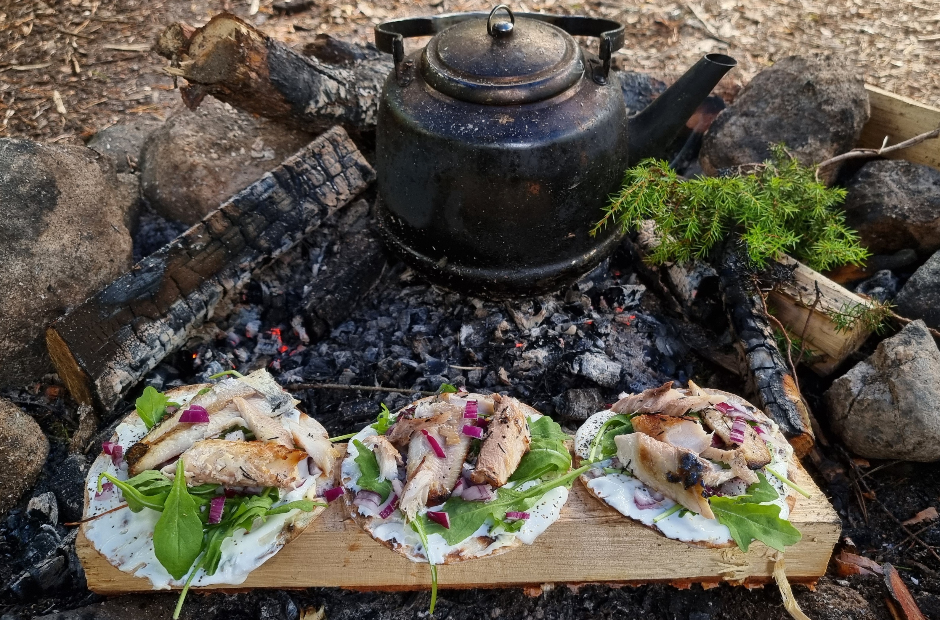 Kaffekittel och läckra wraps vid en utbrunnen lägereld, All in Nature Sweden