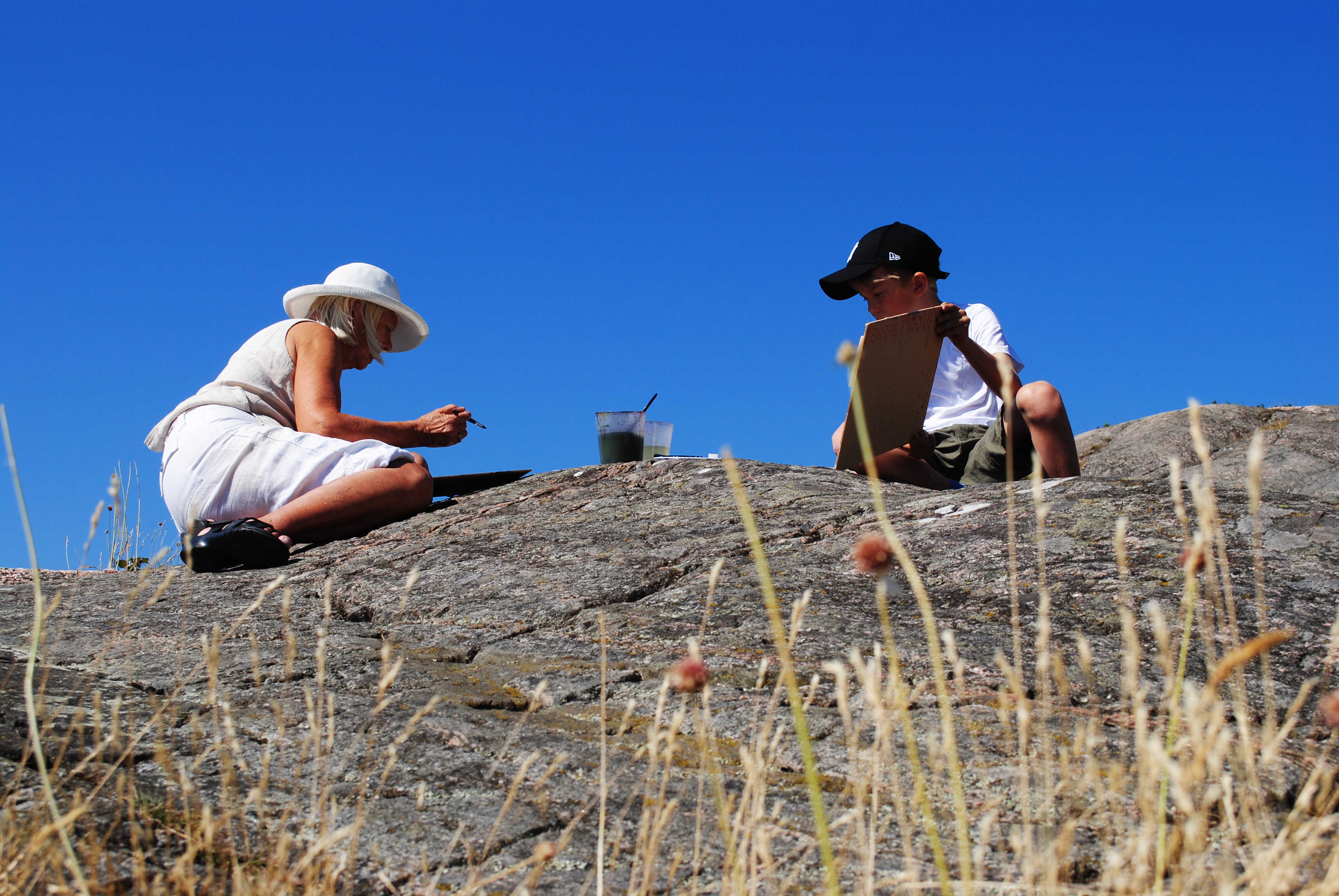 Kursdeltagare målar ute på en klippa, Nordiska Akvarellmuseet
