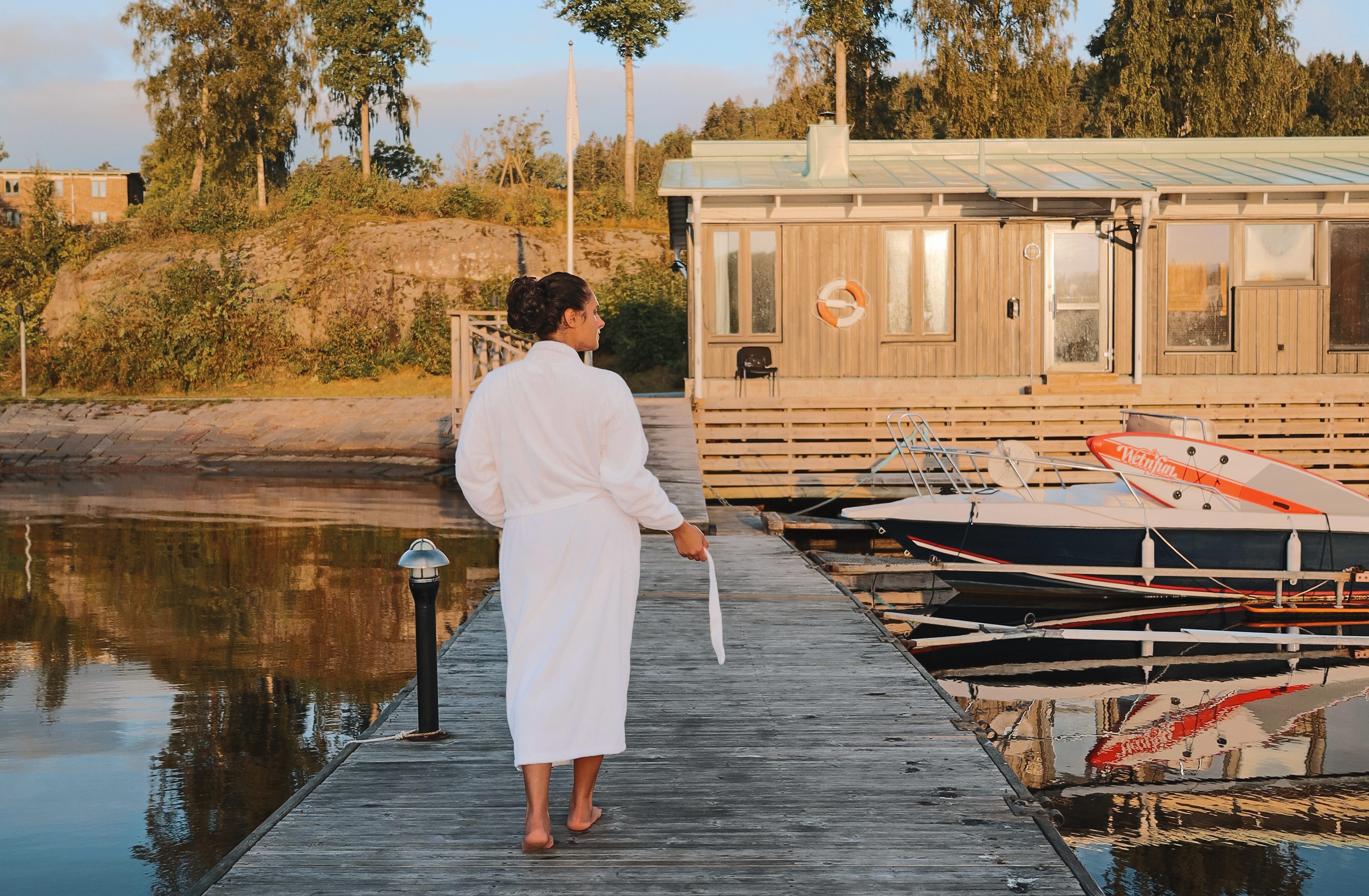 Kvinna, hotellgäst i badrock på badbryggan