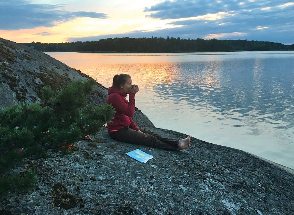 A woman on a cliff with a beautiful sunset