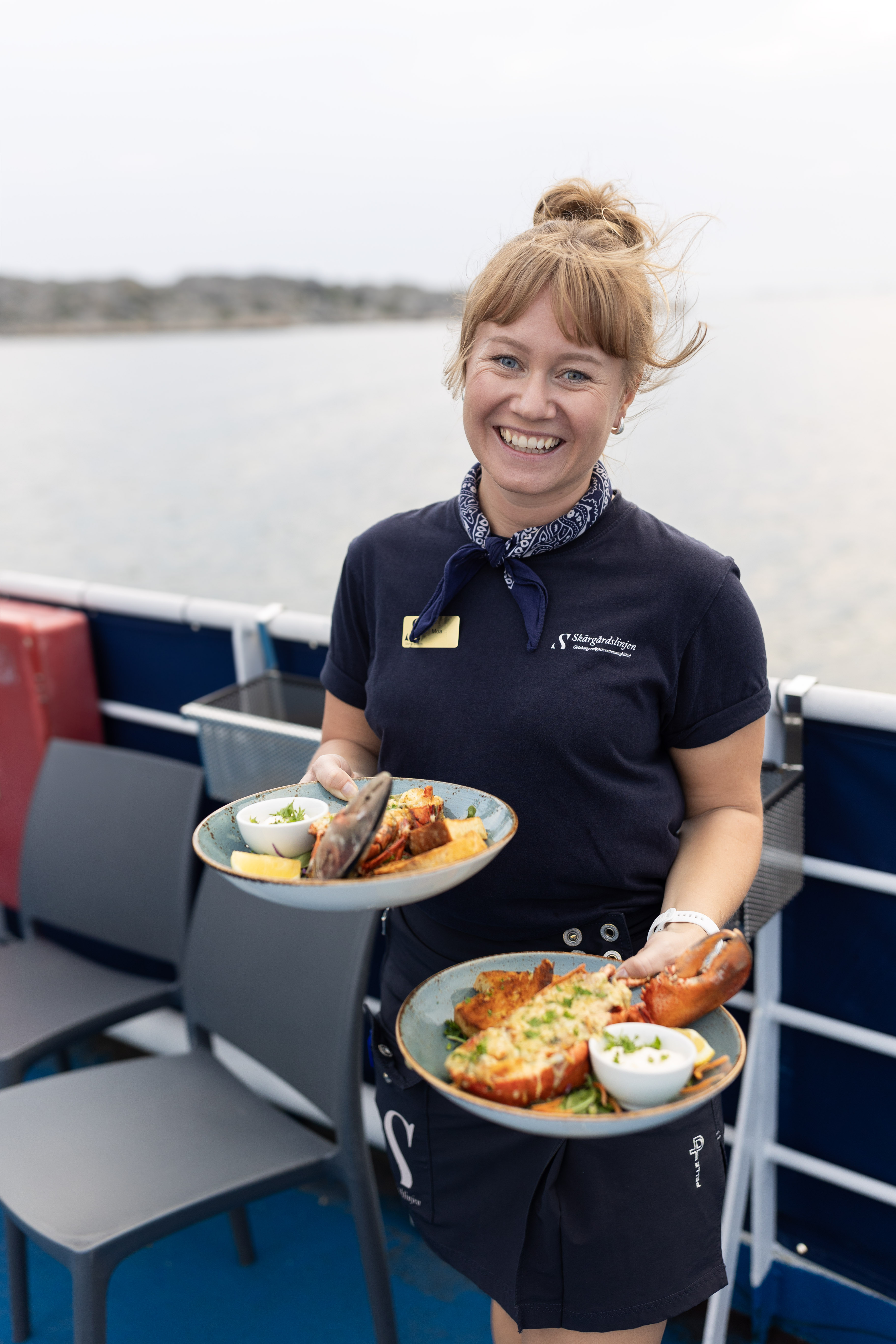 Happy woman serving food on a boat.