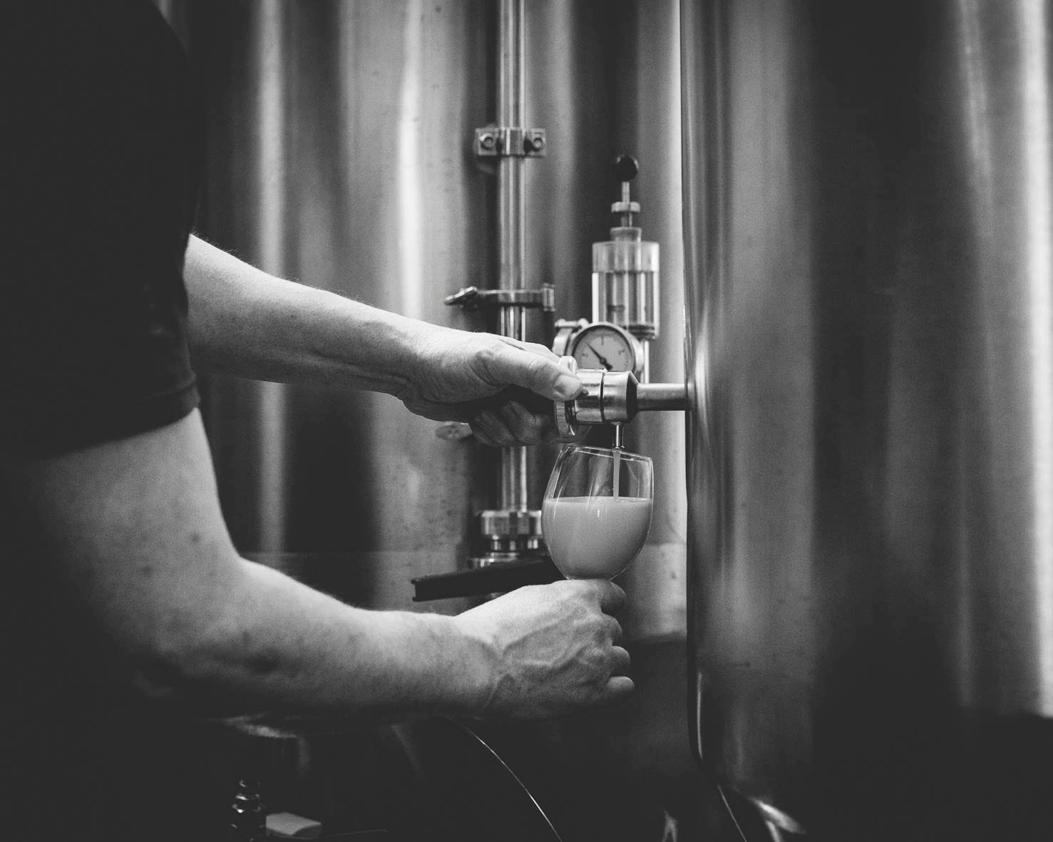 Pouring a glass of beer directly from the copper barrel