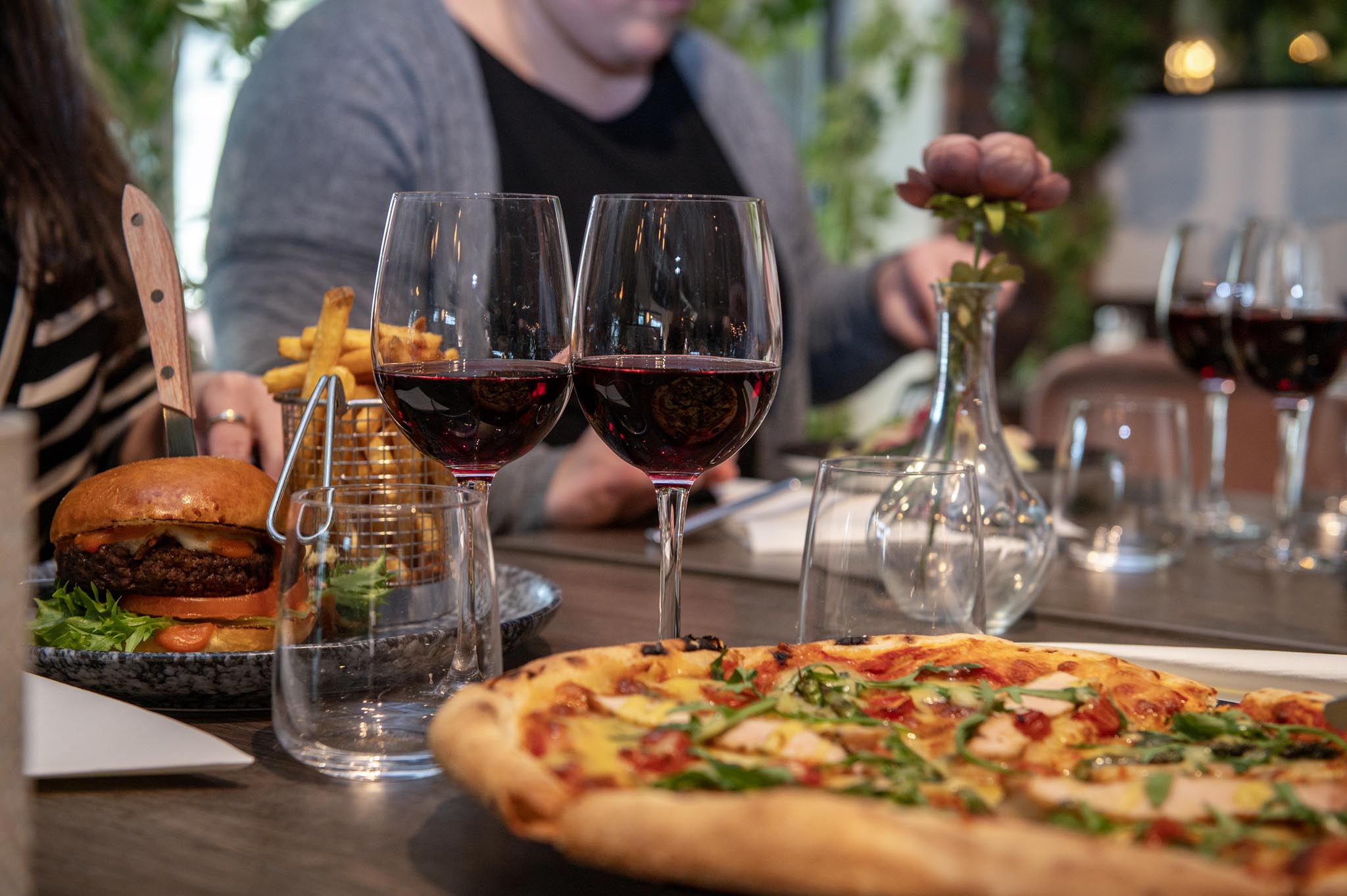 A set dinner table with pizza, red wine i glasses at restaurant Campo, Kviberg Park Hotel & Conference