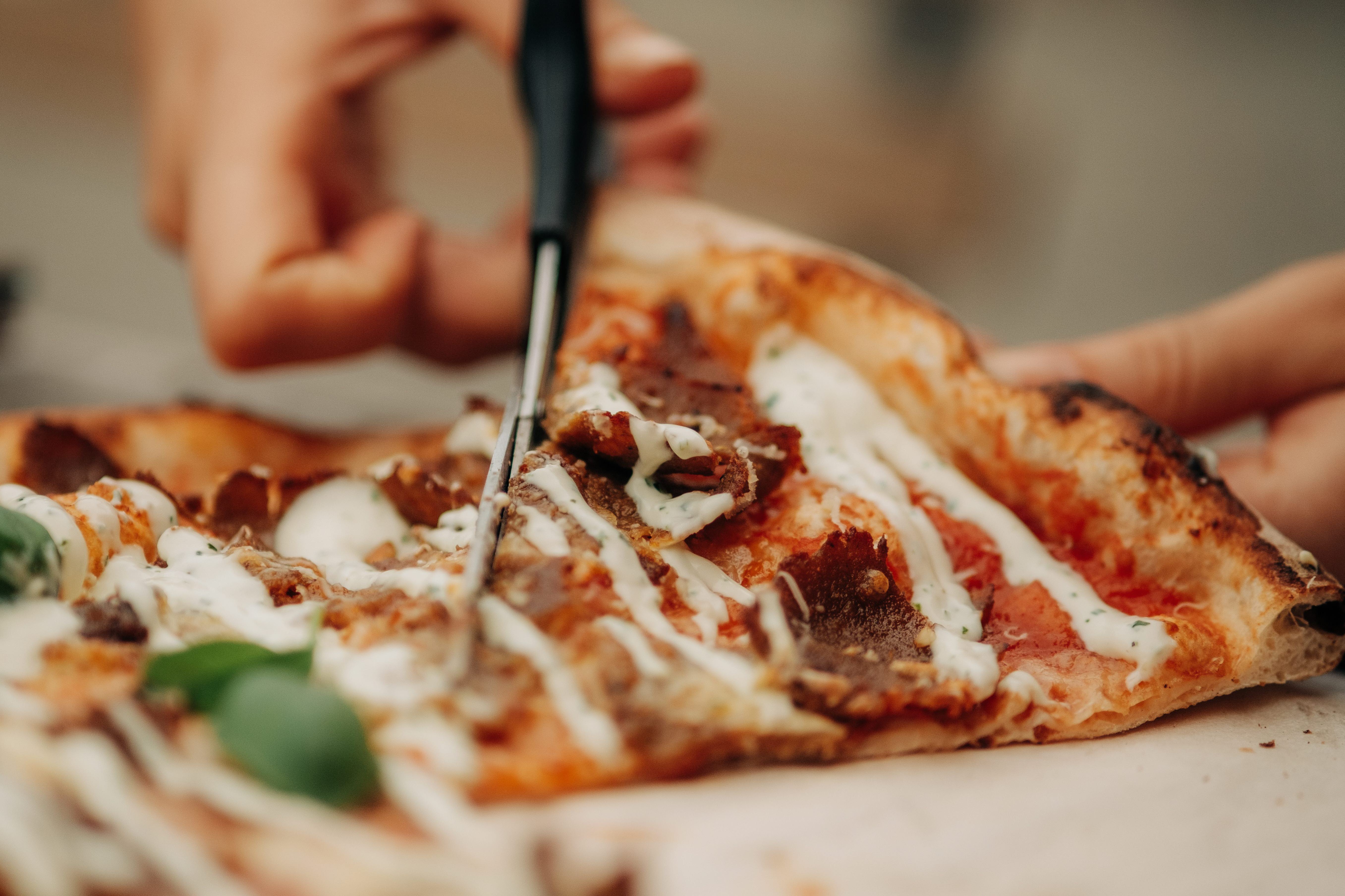 Vedugnsbakad pizza delas med sax på Vedens Lustgård