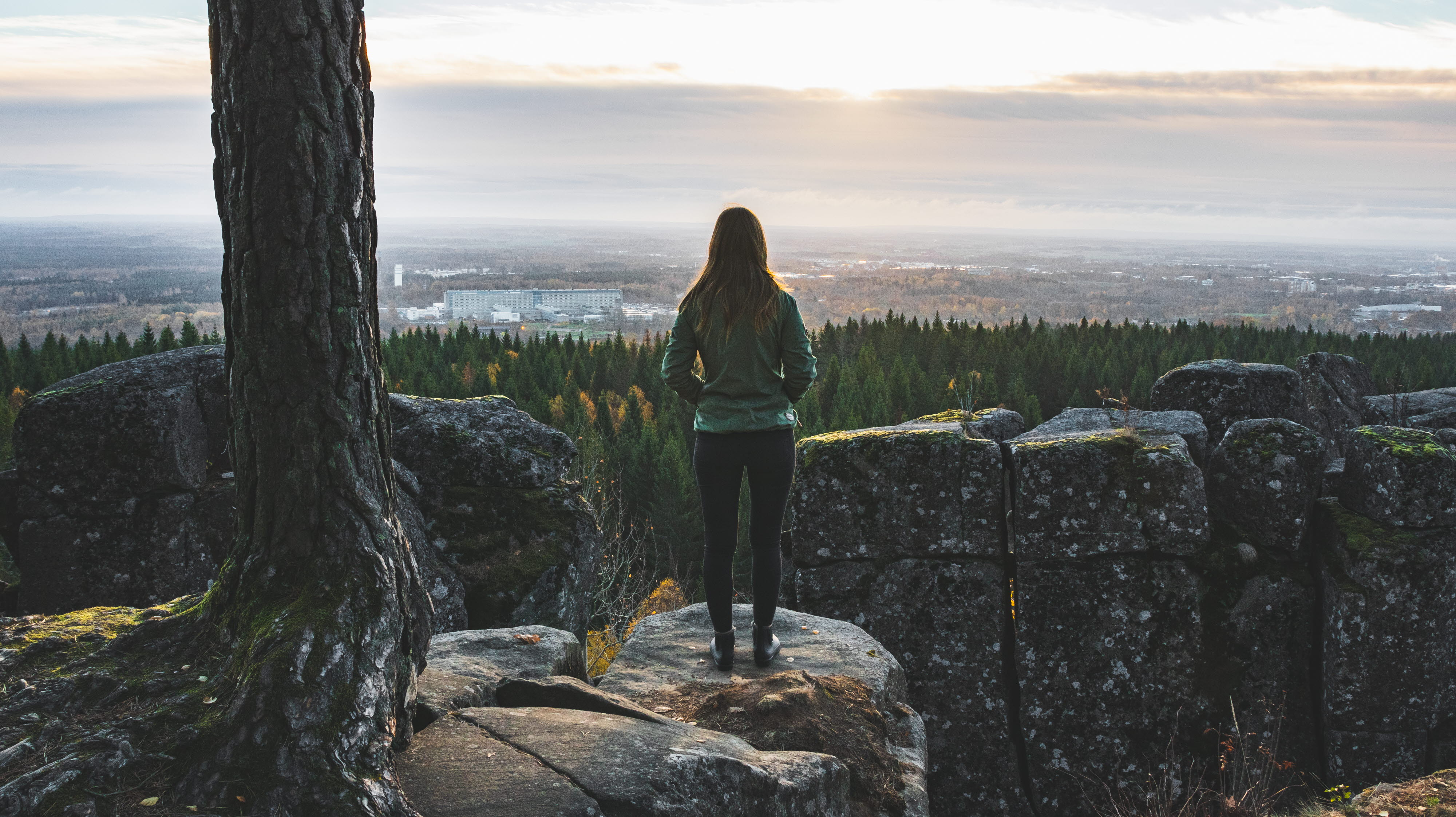 Kvinna tittar ut från ett berg över Platåbergens Geopark