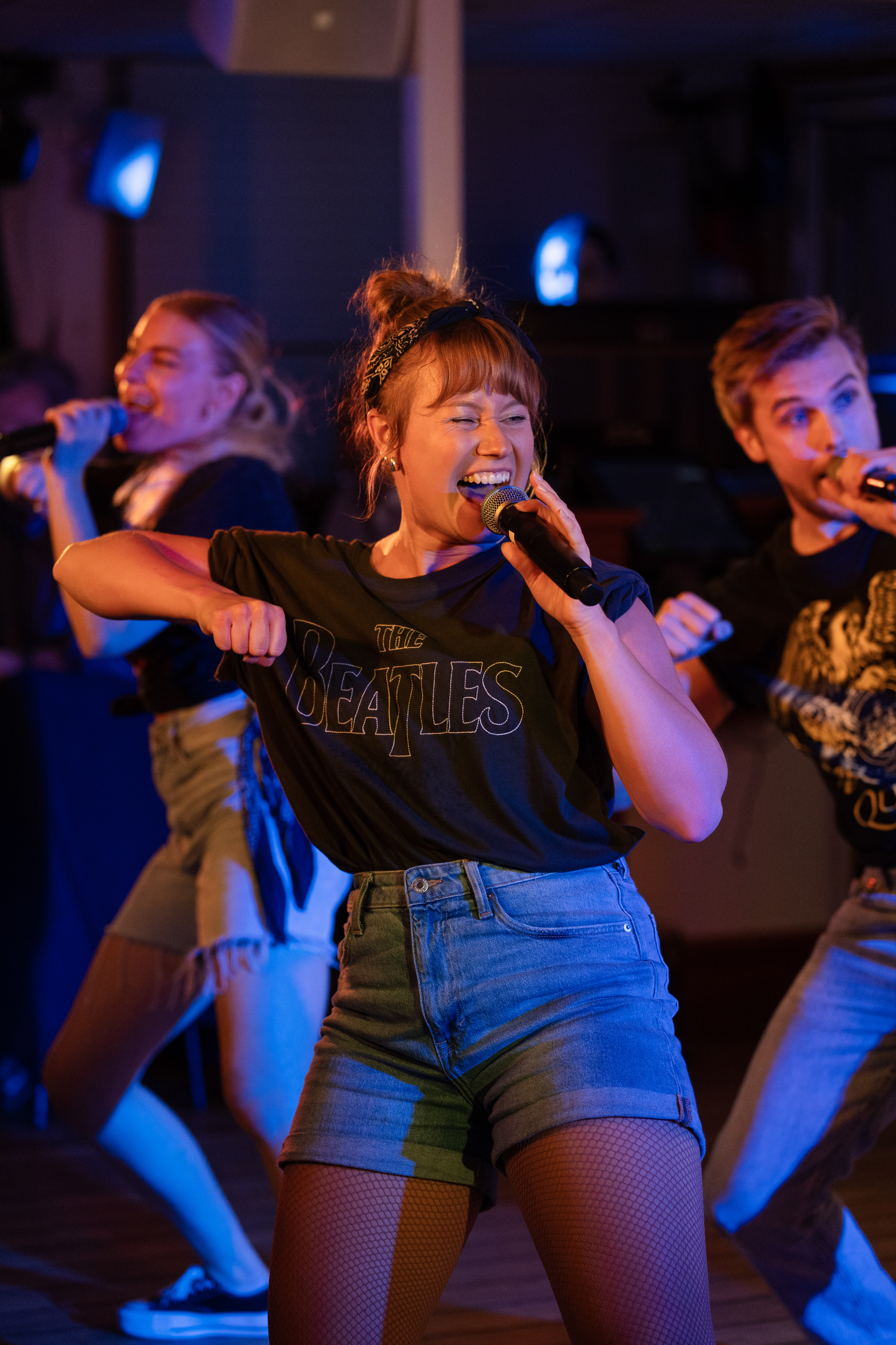 Happy woman singing and dancing on a stage.