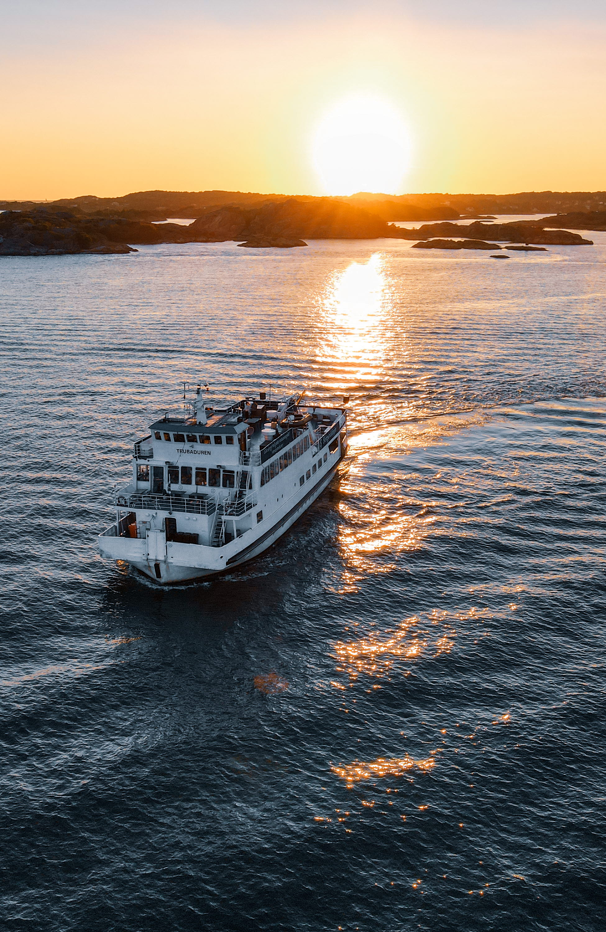 Kryssningsbåt ute på havet i solnedgången.