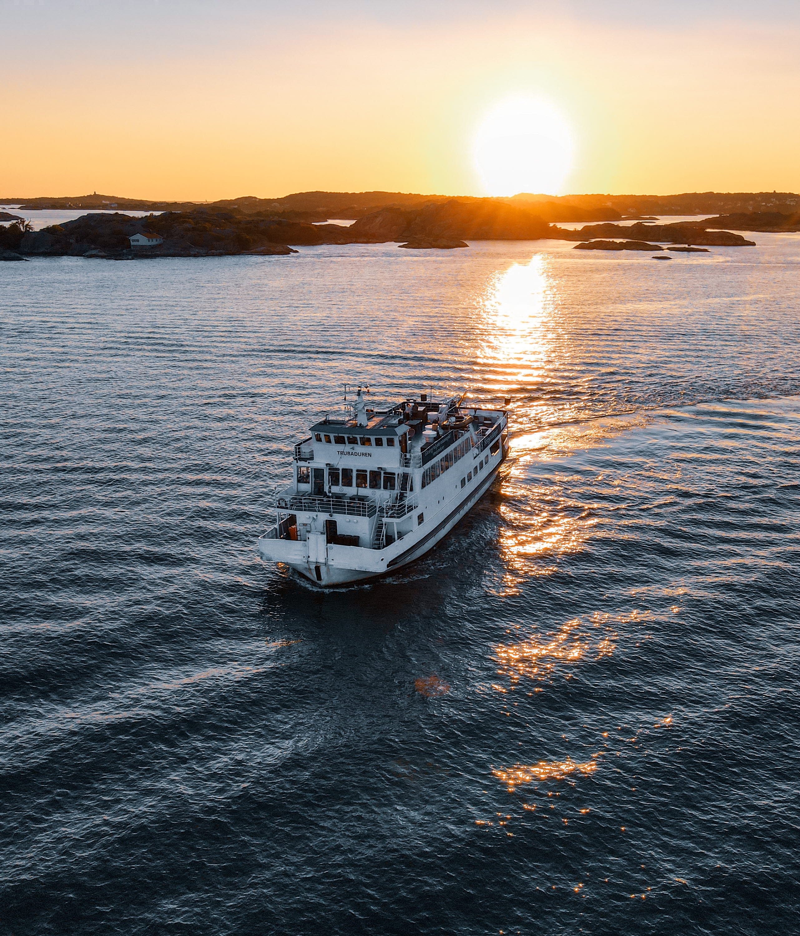Kryssningsbåt ute på havet i solnedgången.