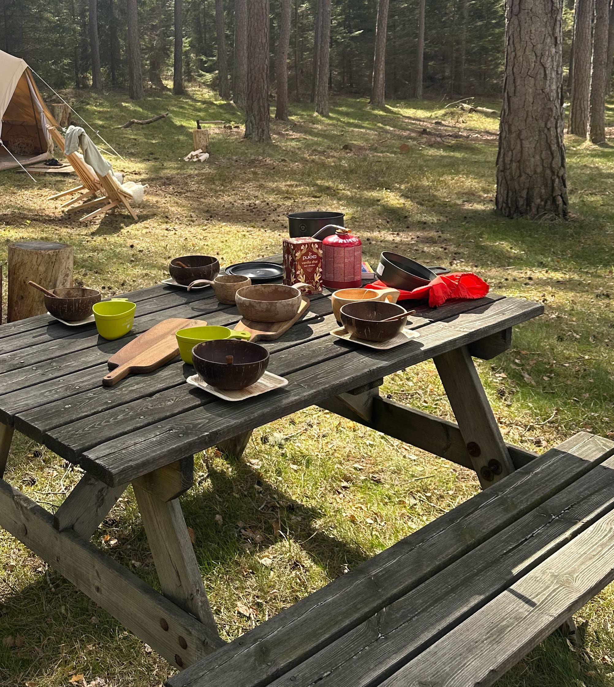 Dukat picknick bord med glampingtält i bakgrunden