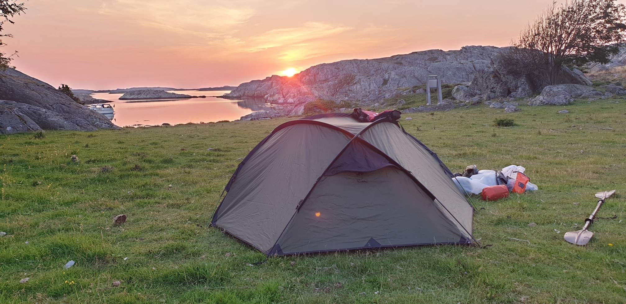 Tält i en badvik med en vacker solnedgång 