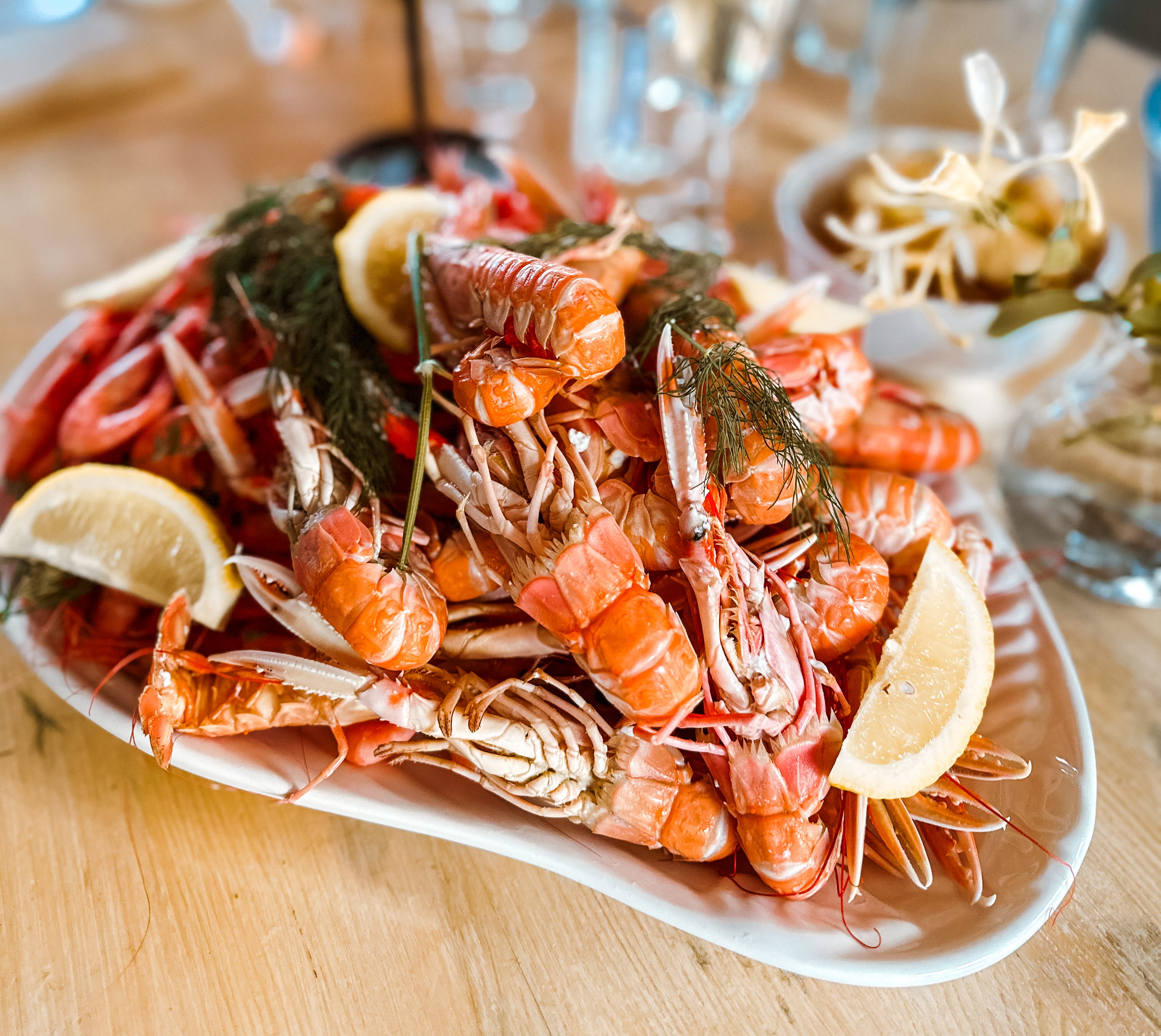 A seafood dinner with lobsters, lemon wedges and shrimps served in the restaurant at Hotell Smögens Hafvsbad