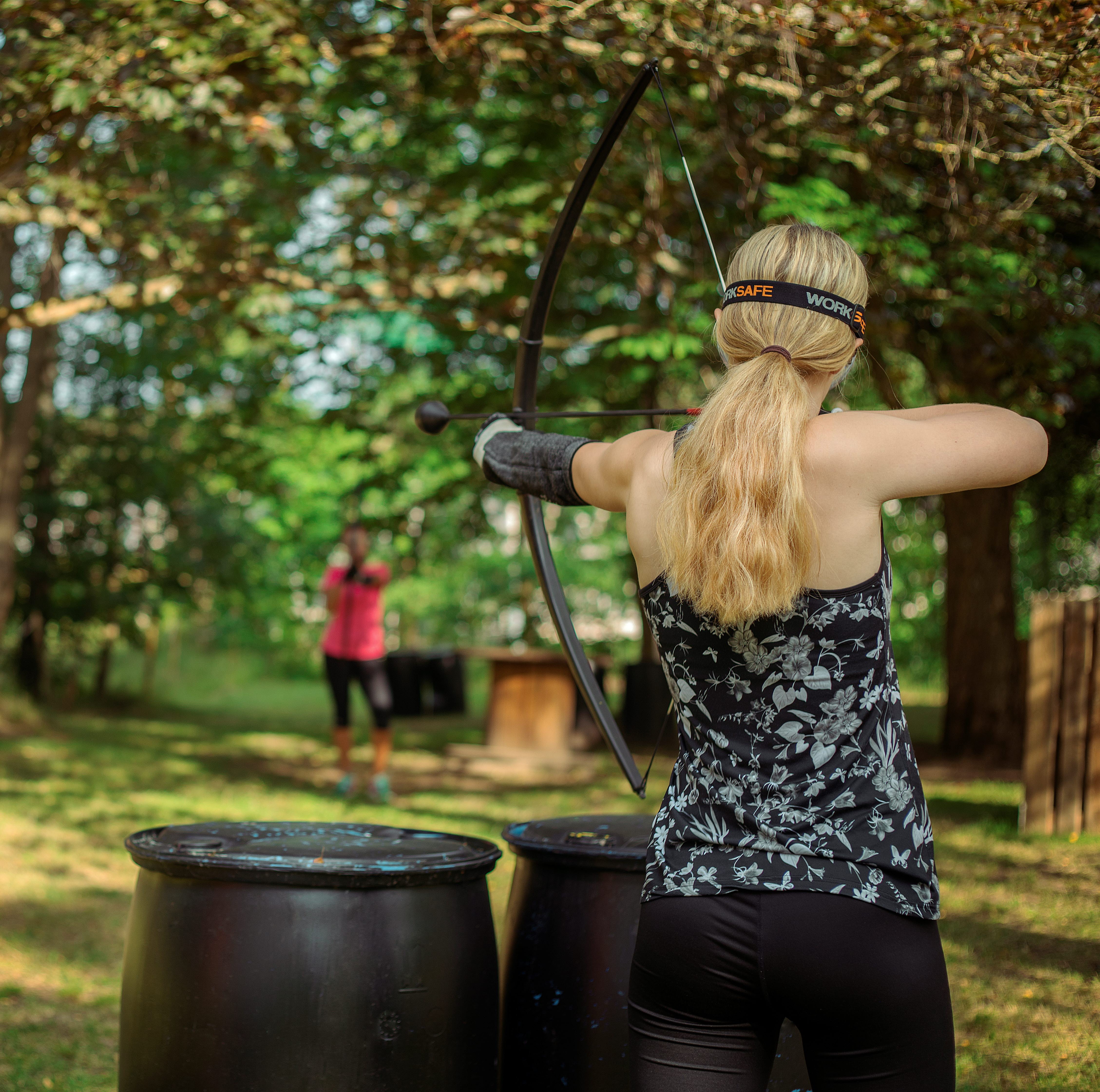 Kvinna skjuter pilbåge på Upzone.