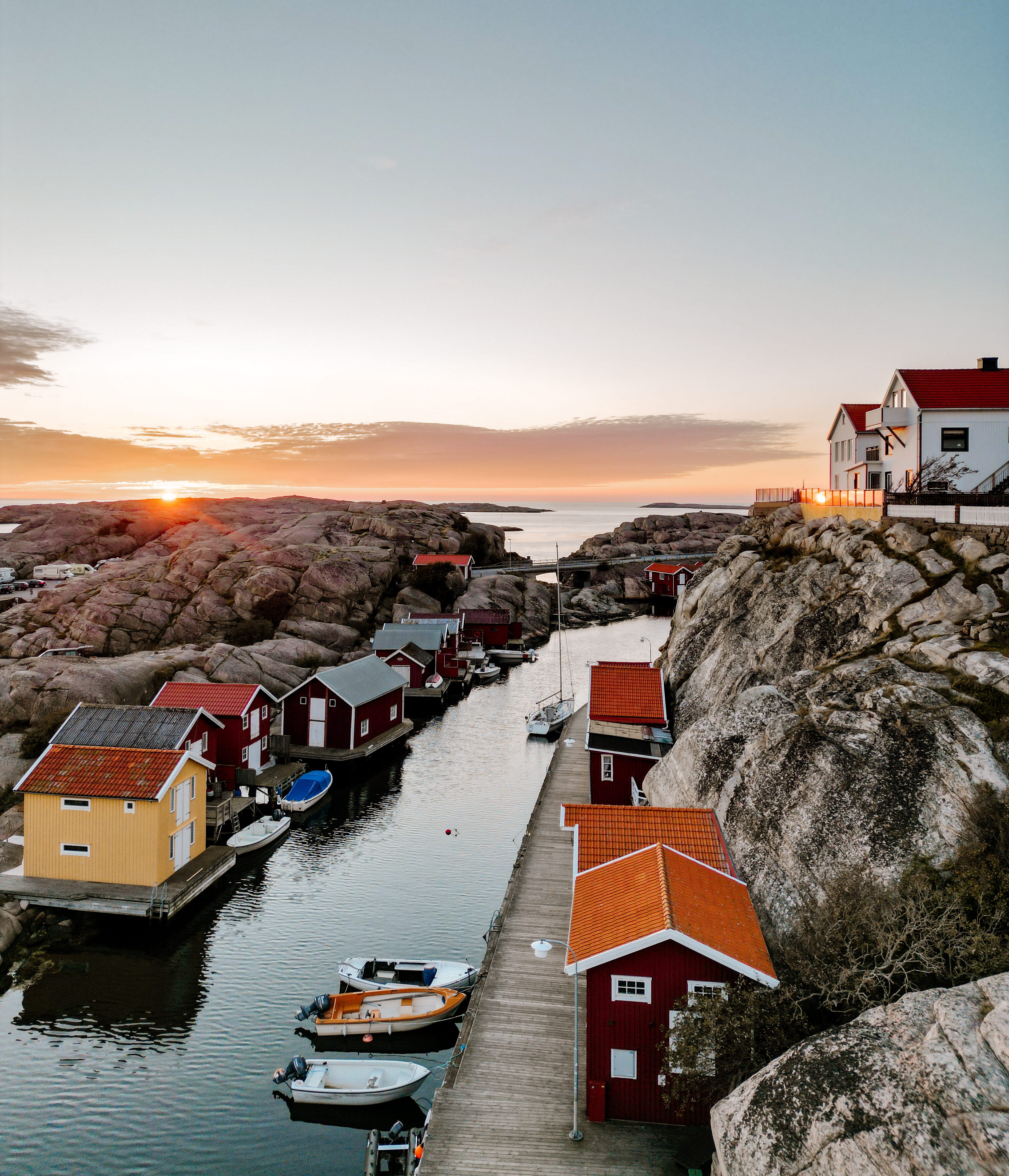 Vacker vy i solnedgång över Smögenbryggans fiskebodar, hus och klippor, Hotell Smögens Hafvsbad