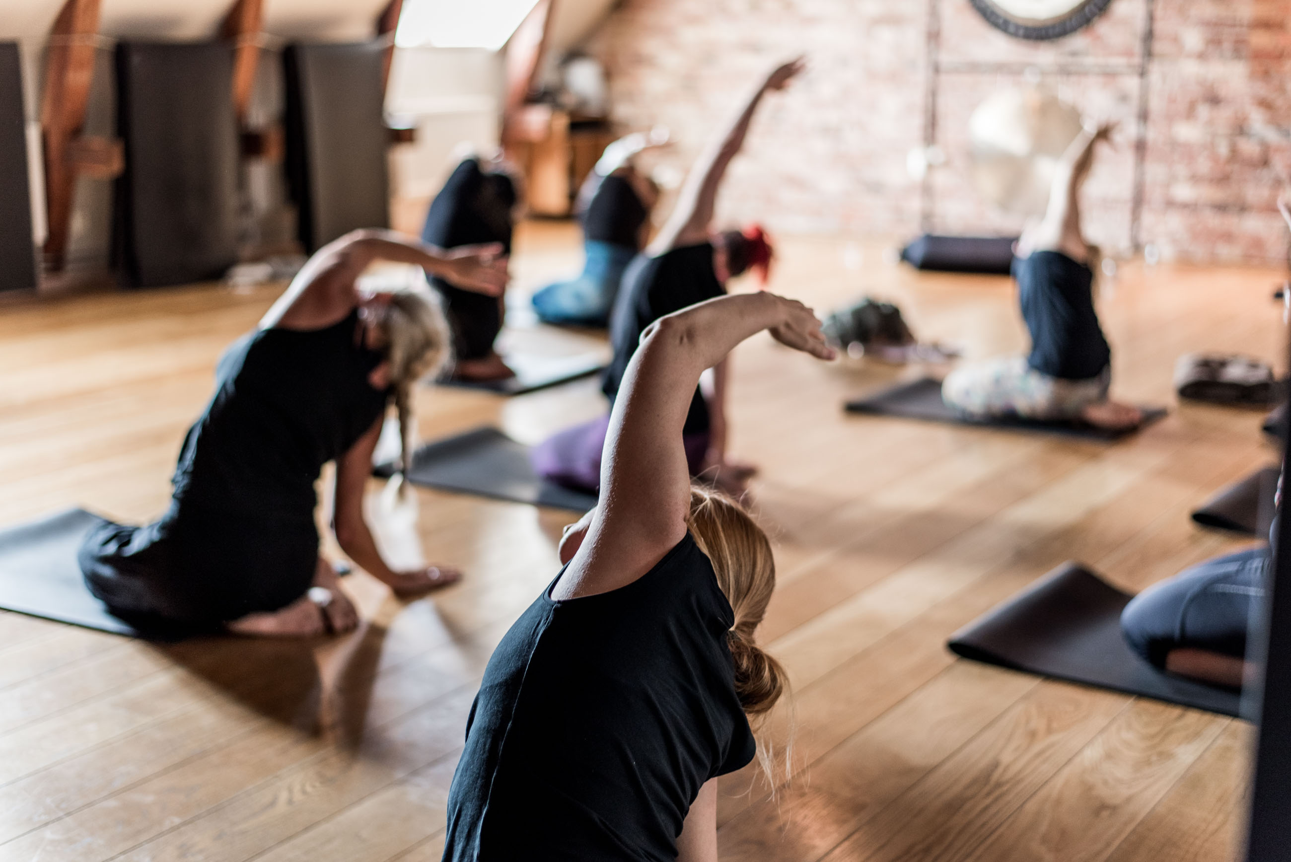 Mörk yogasal med människor som utövar yoga.