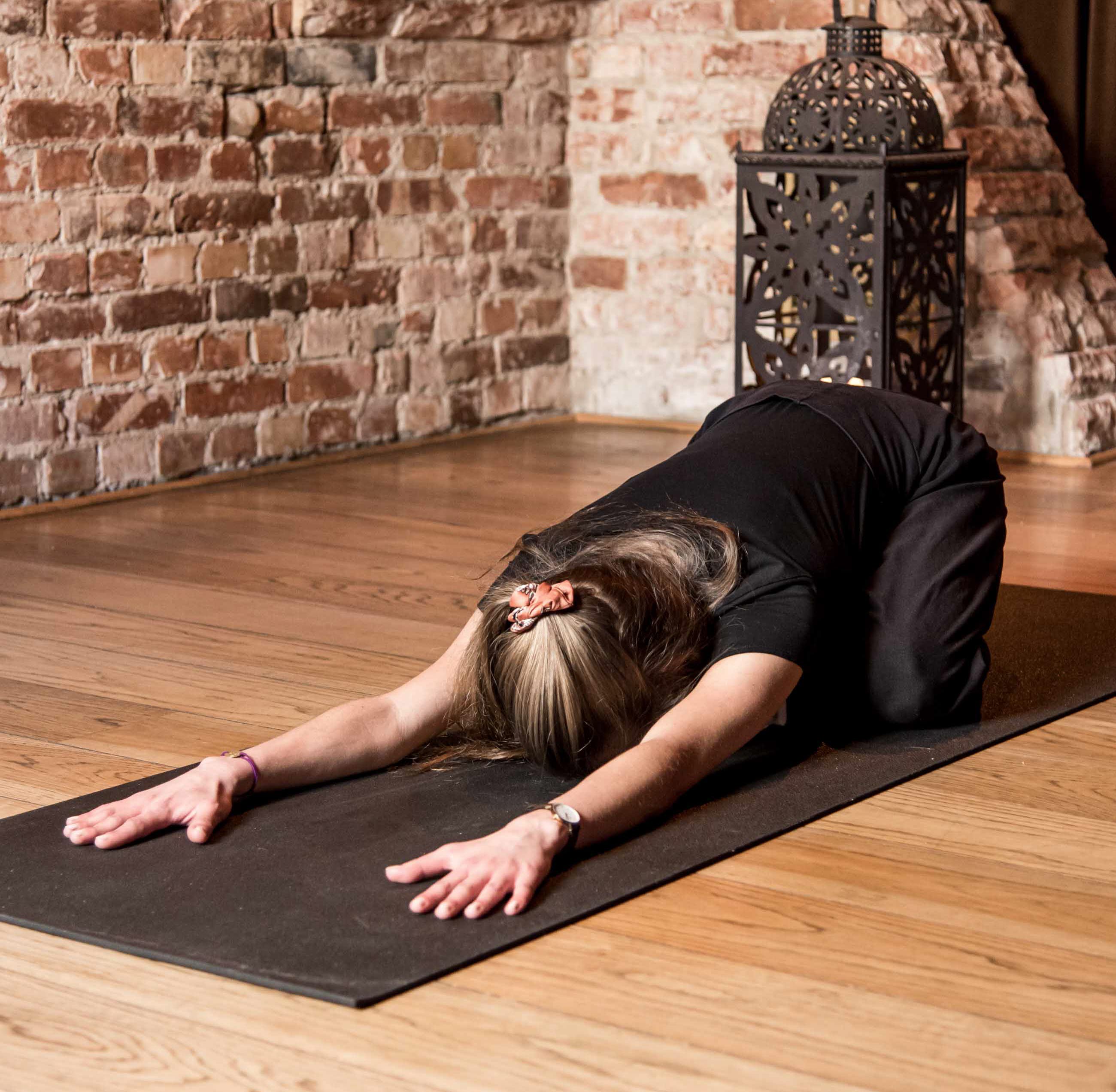 Mörk yogasal med människor som utövar yoga.