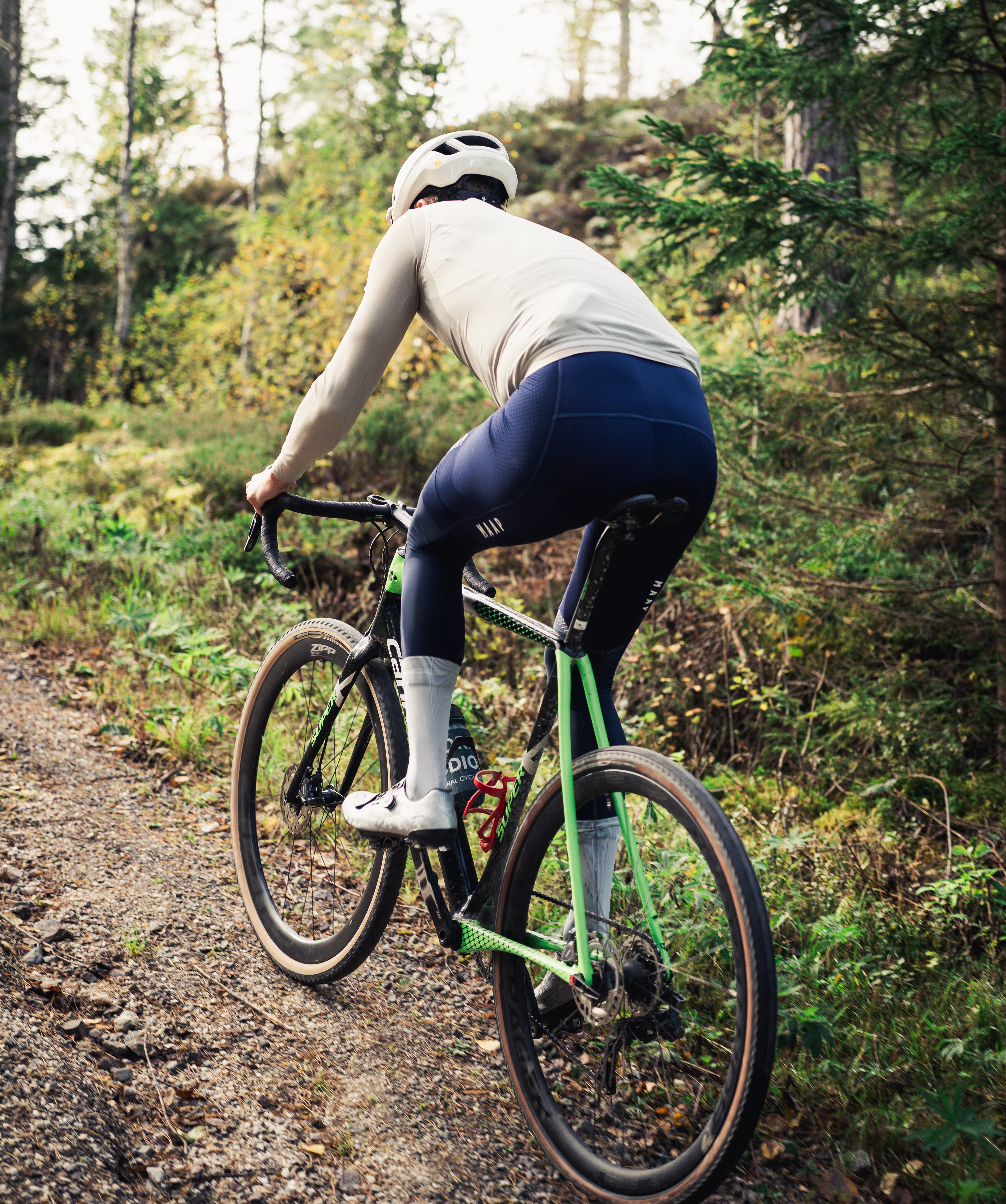 Cyklist på en grusväg i bruksmiljö.
