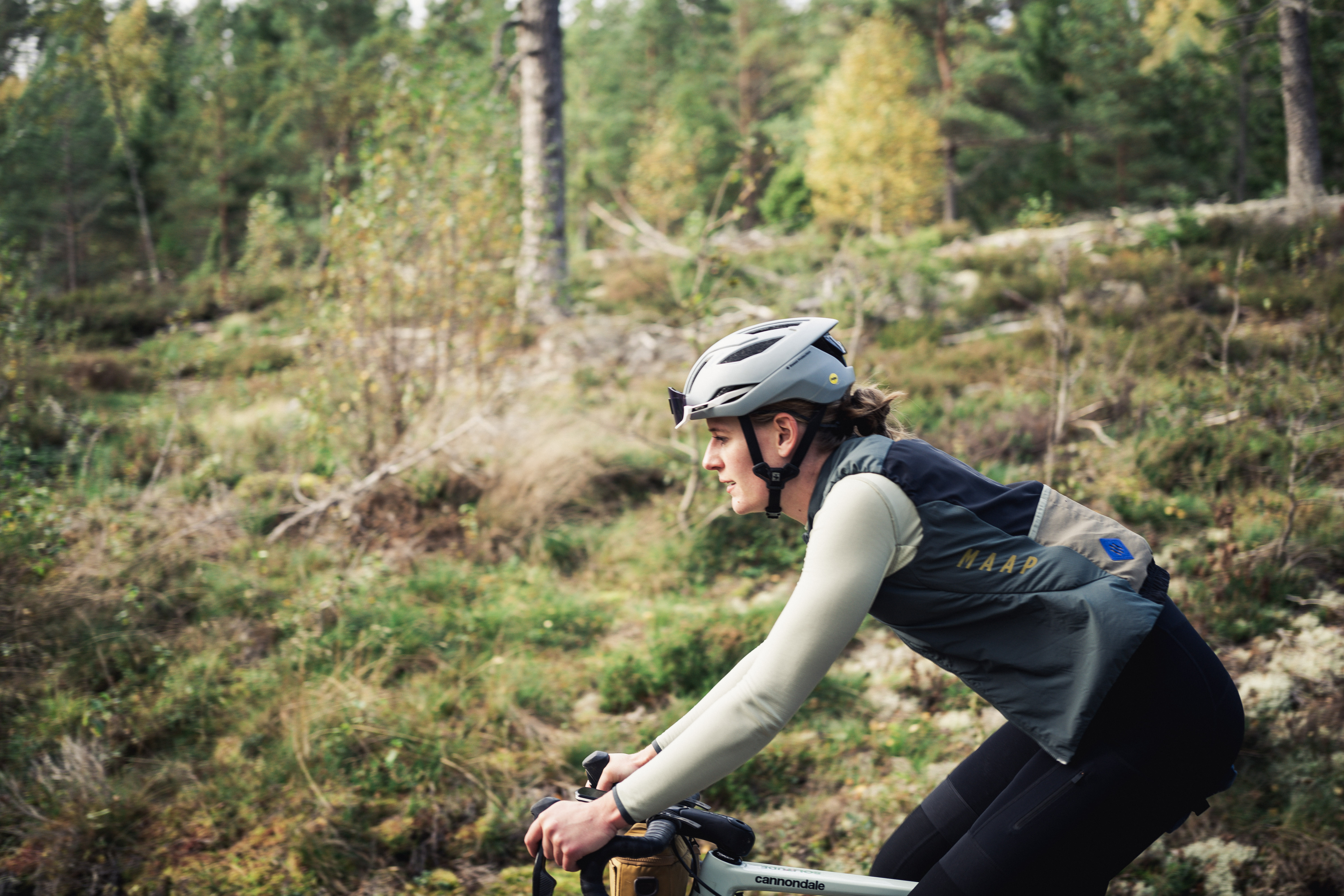 Cyklist på en grusväg i bruksmiljö.