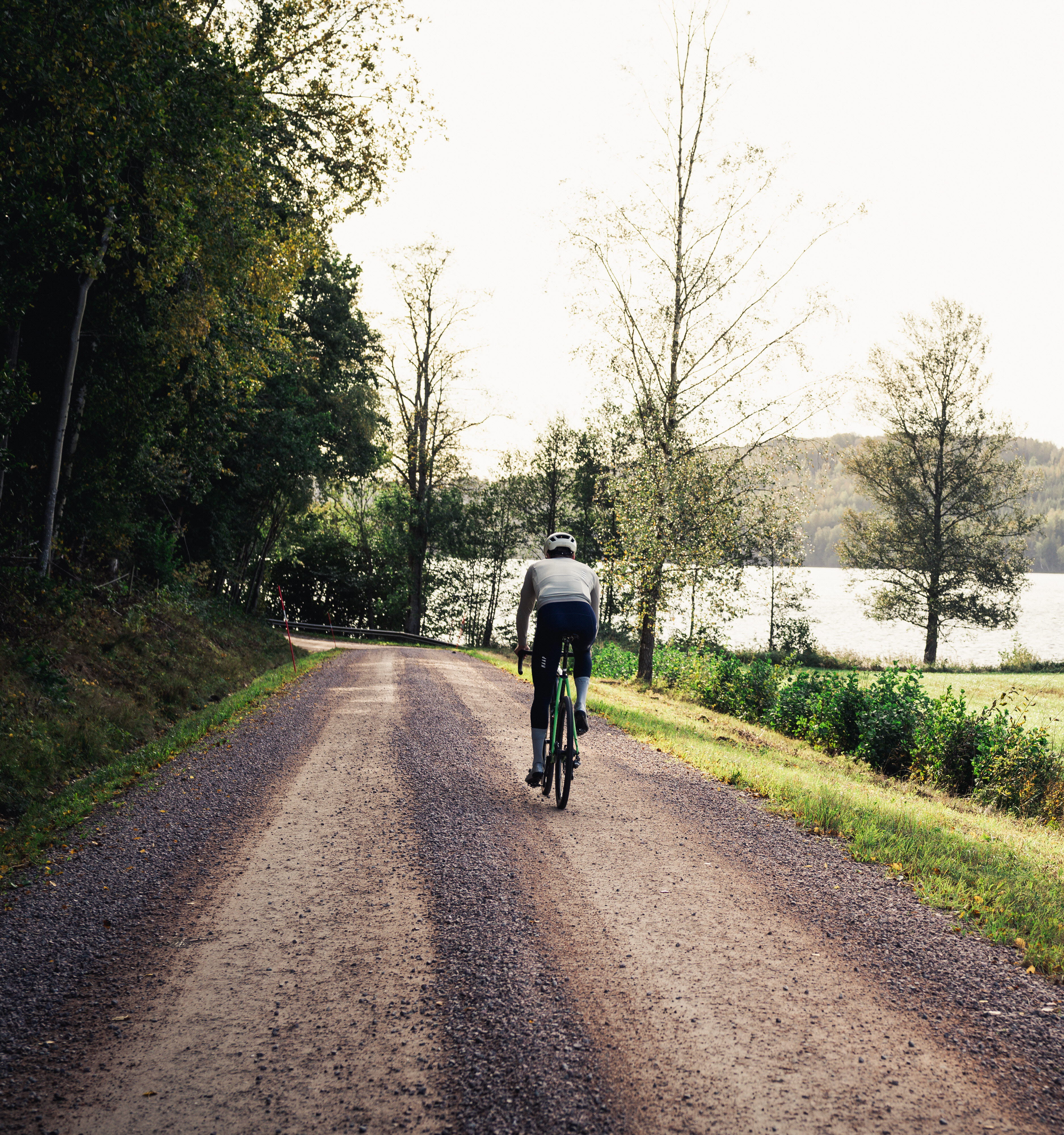 Cyclists on a dirt road in a working environment.