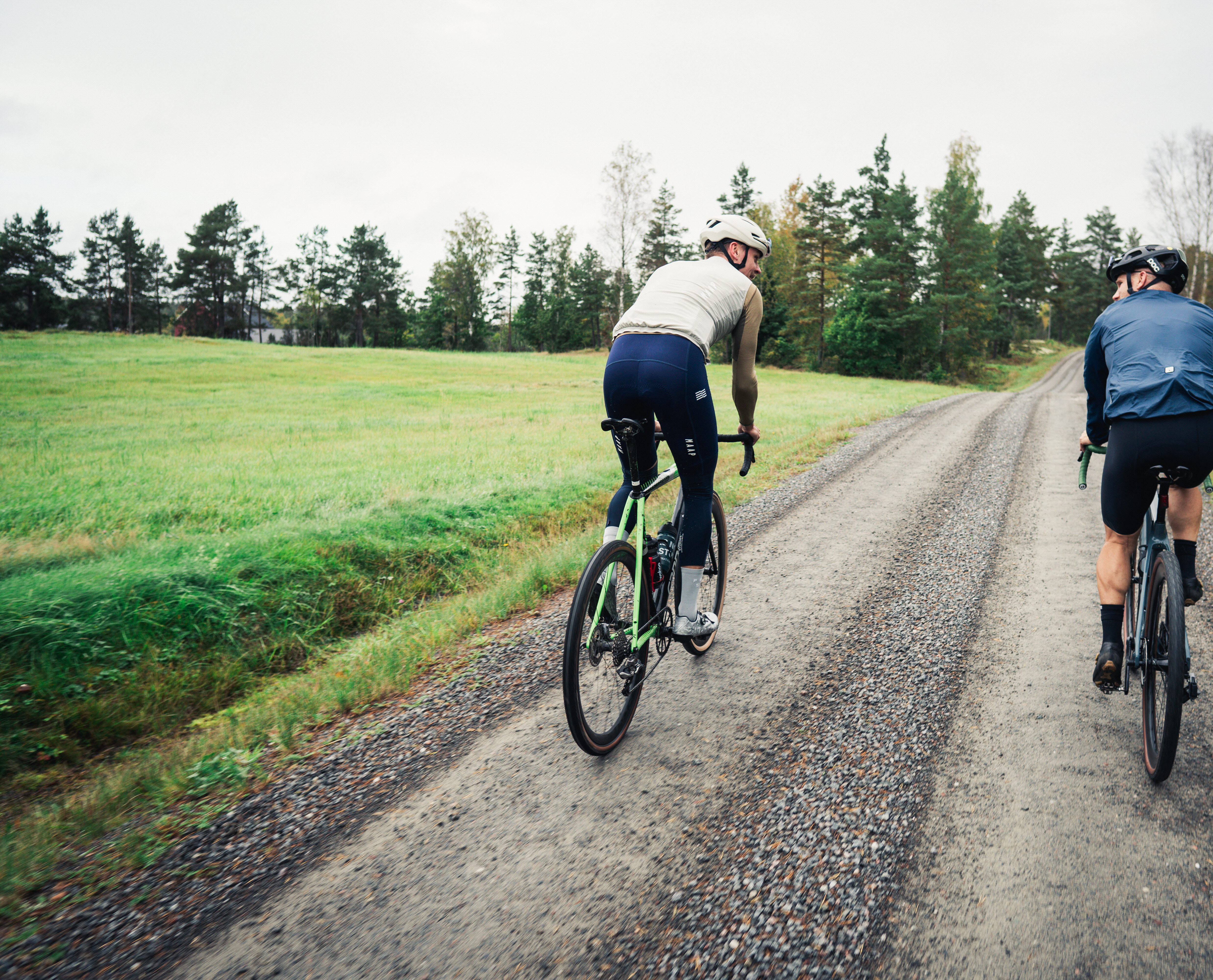 Cyclists on a dirt road in the forest.