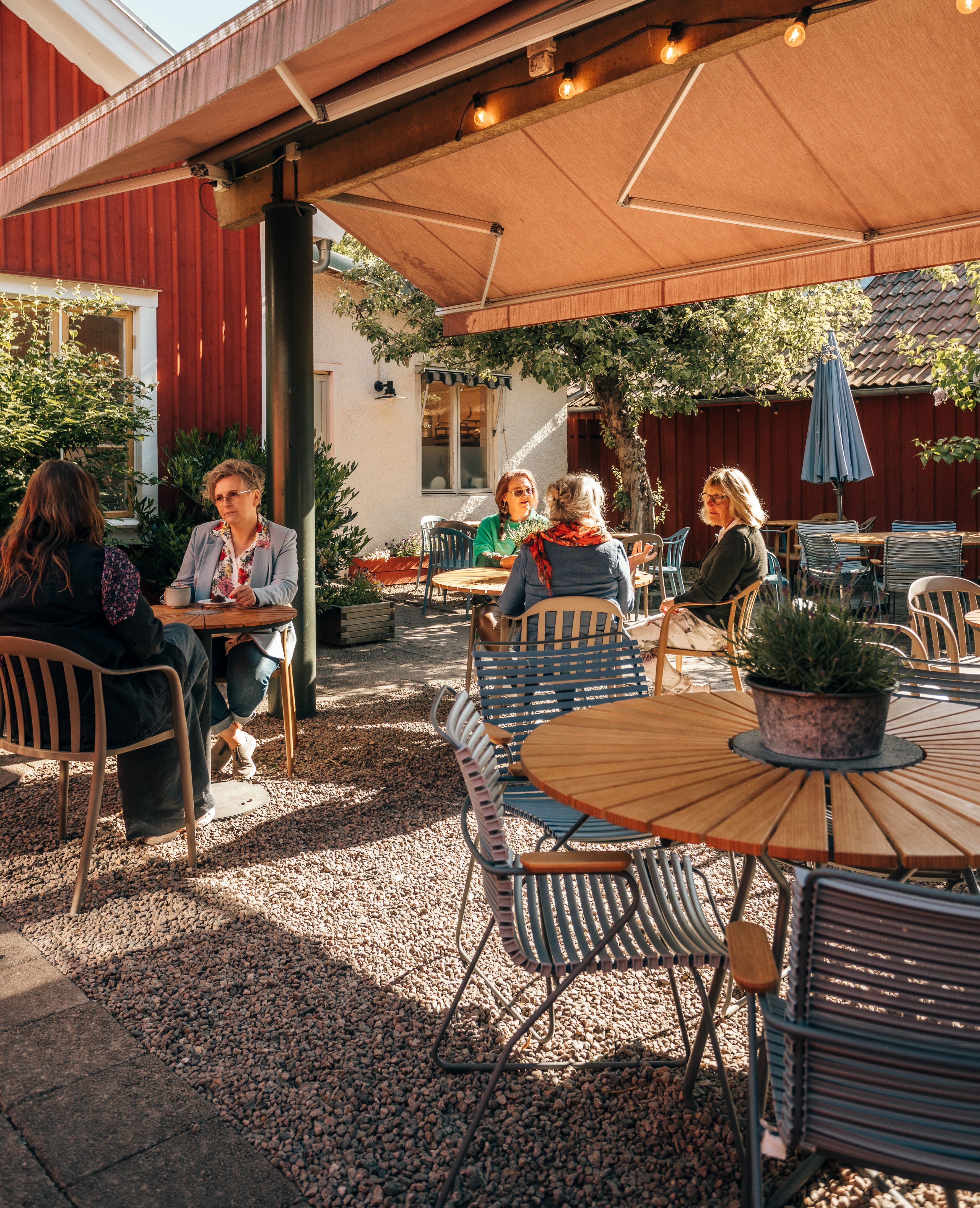 Group of people sitting on an outdoor terrace.