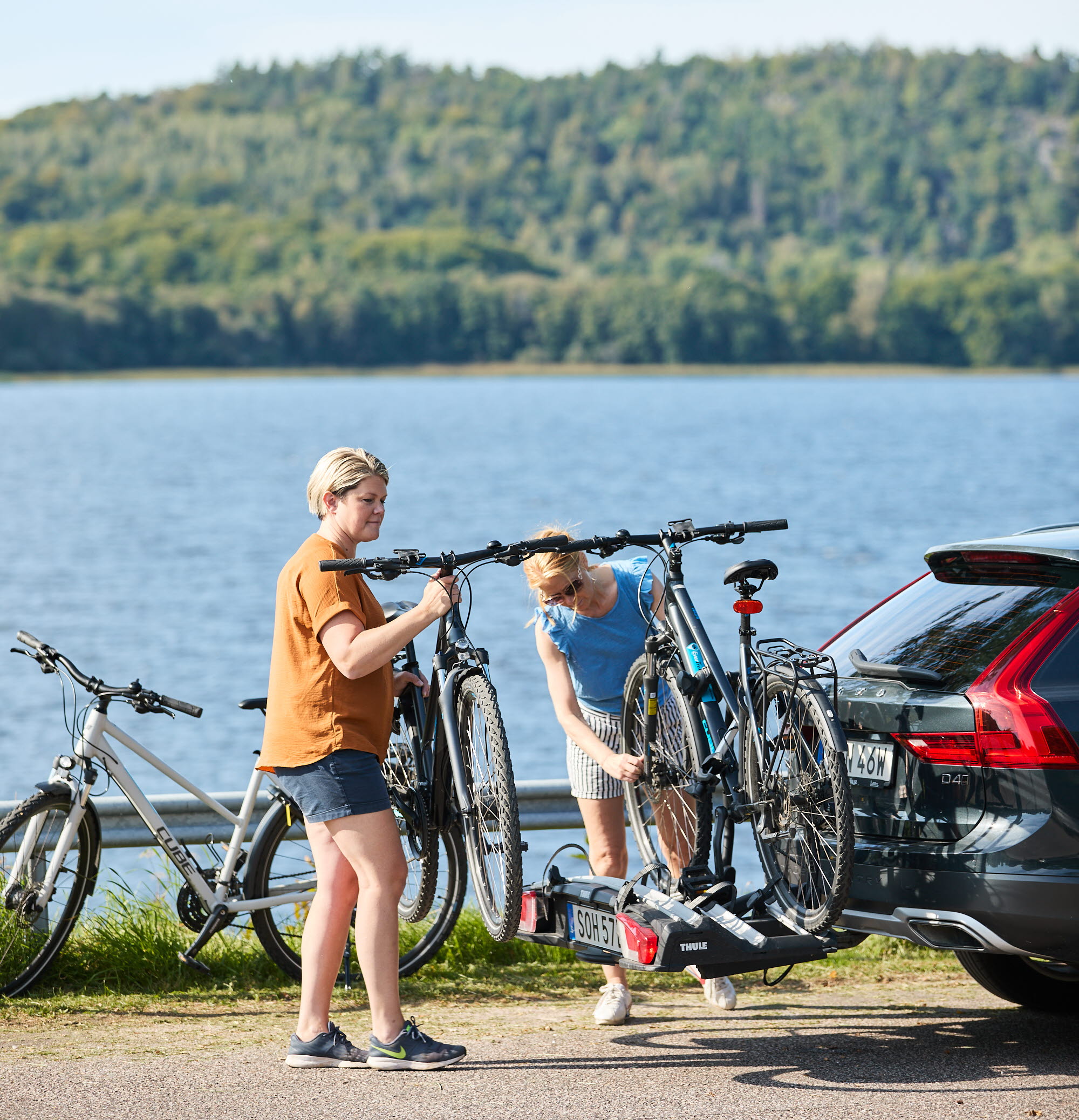 Kvinnor packar cyklar på bil