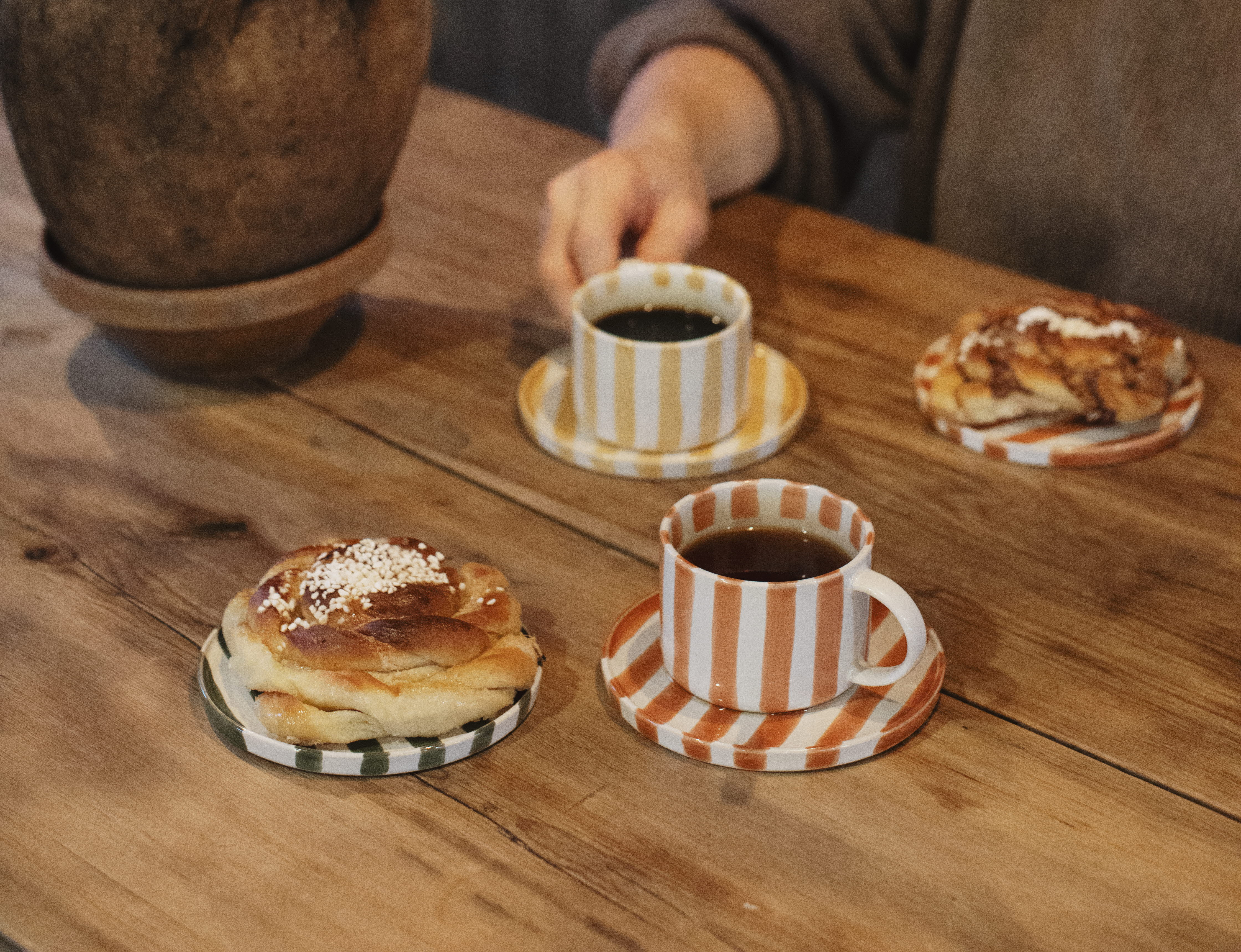 Kvinna håller i en kopp på ett kafé.