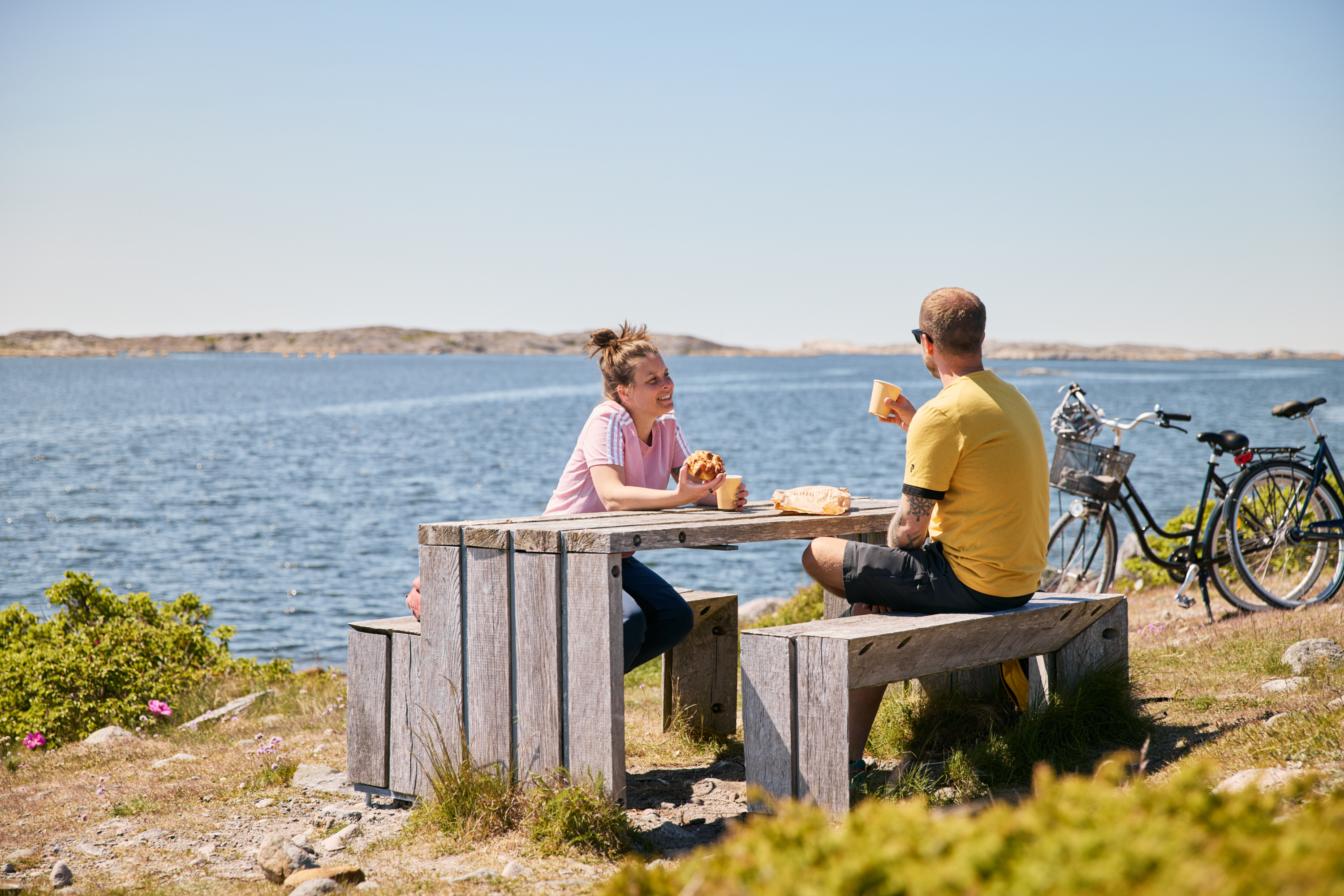 Två personer fikar vid ett bord.