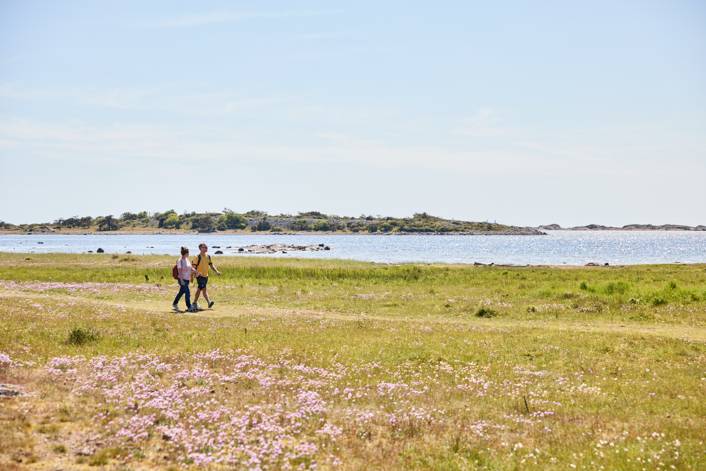 Two people are hiking on an island.