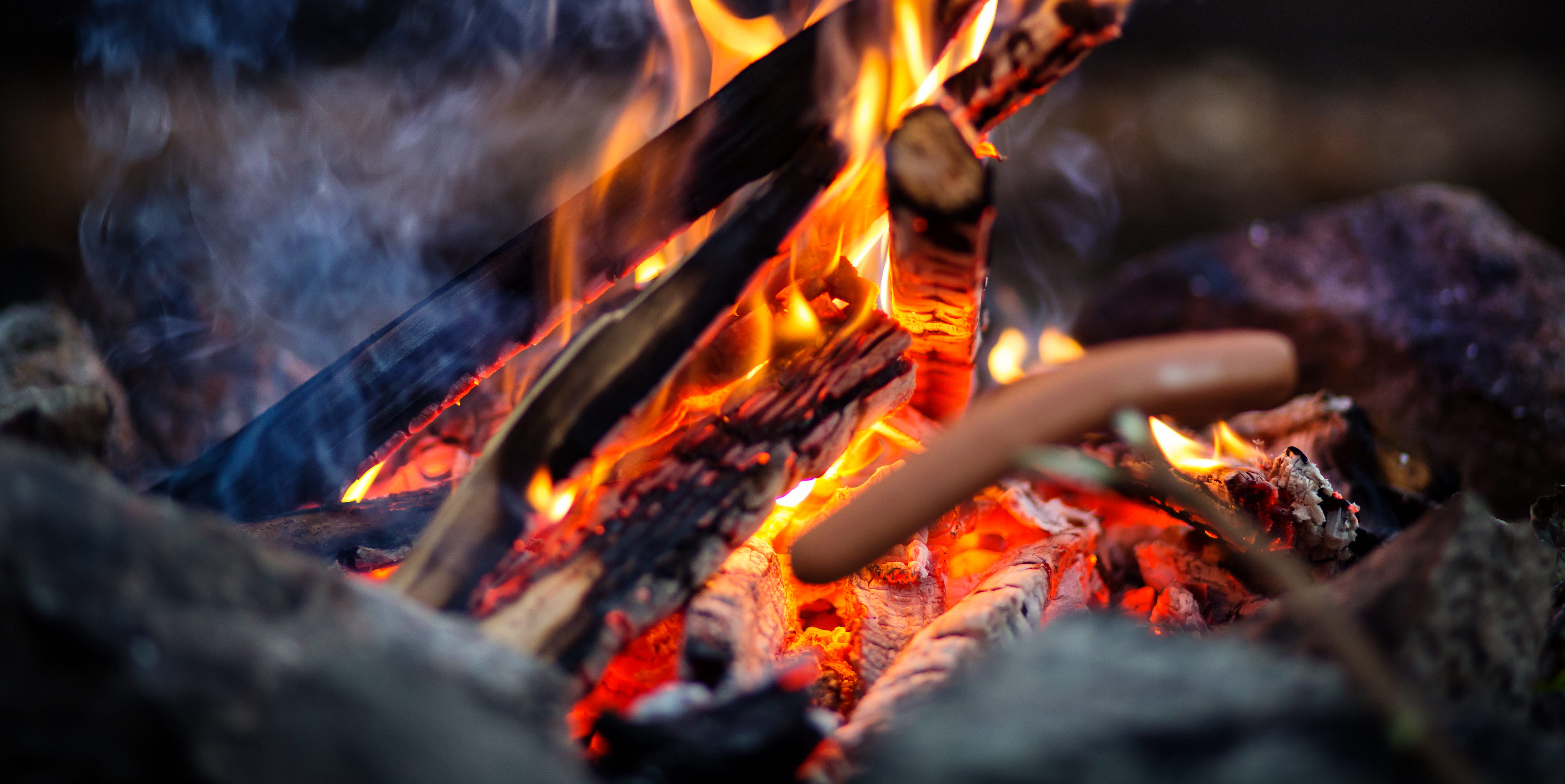 Korv på pinne över lägereld