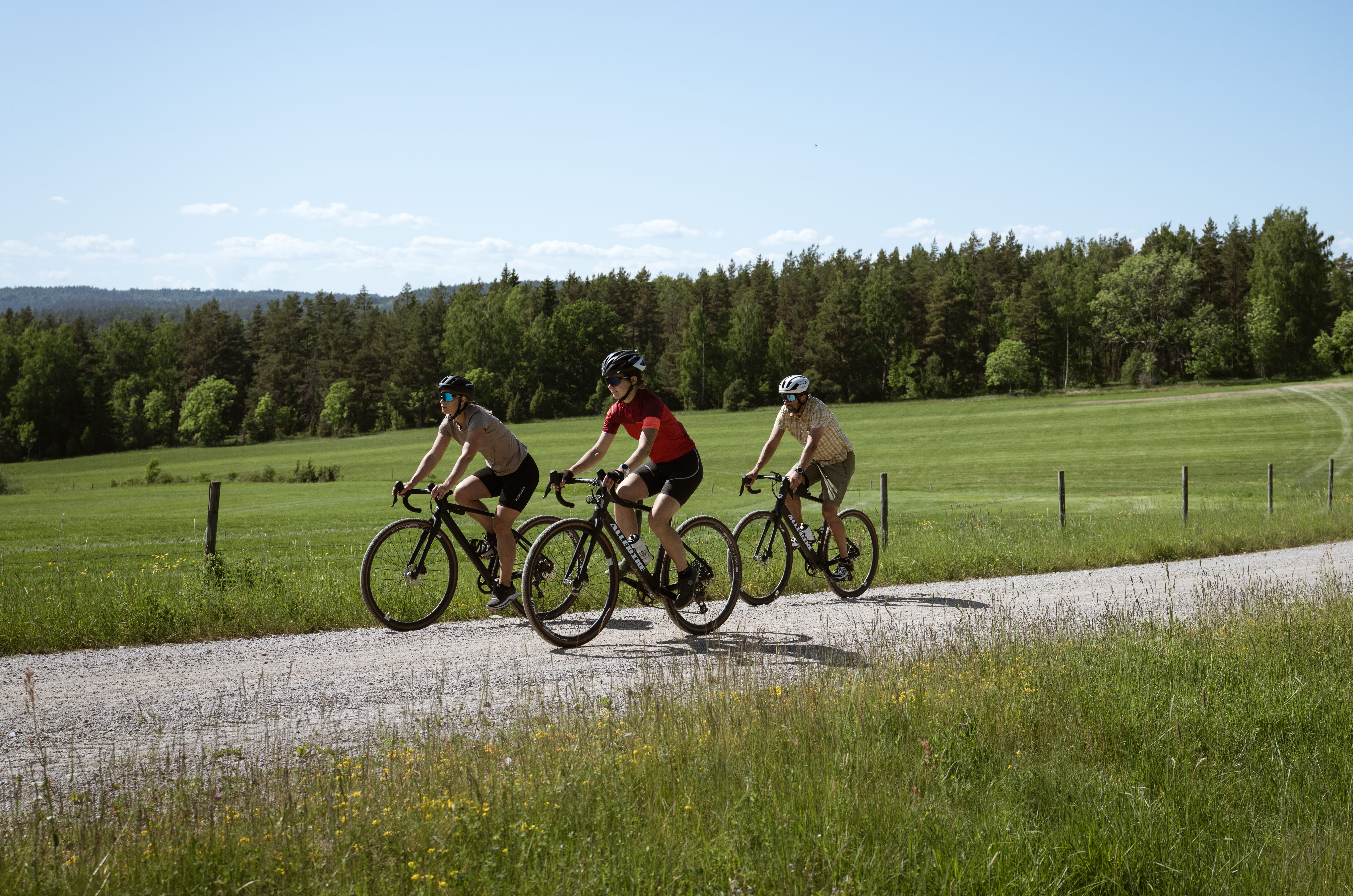 Cyklister på en grusväg i skogen.