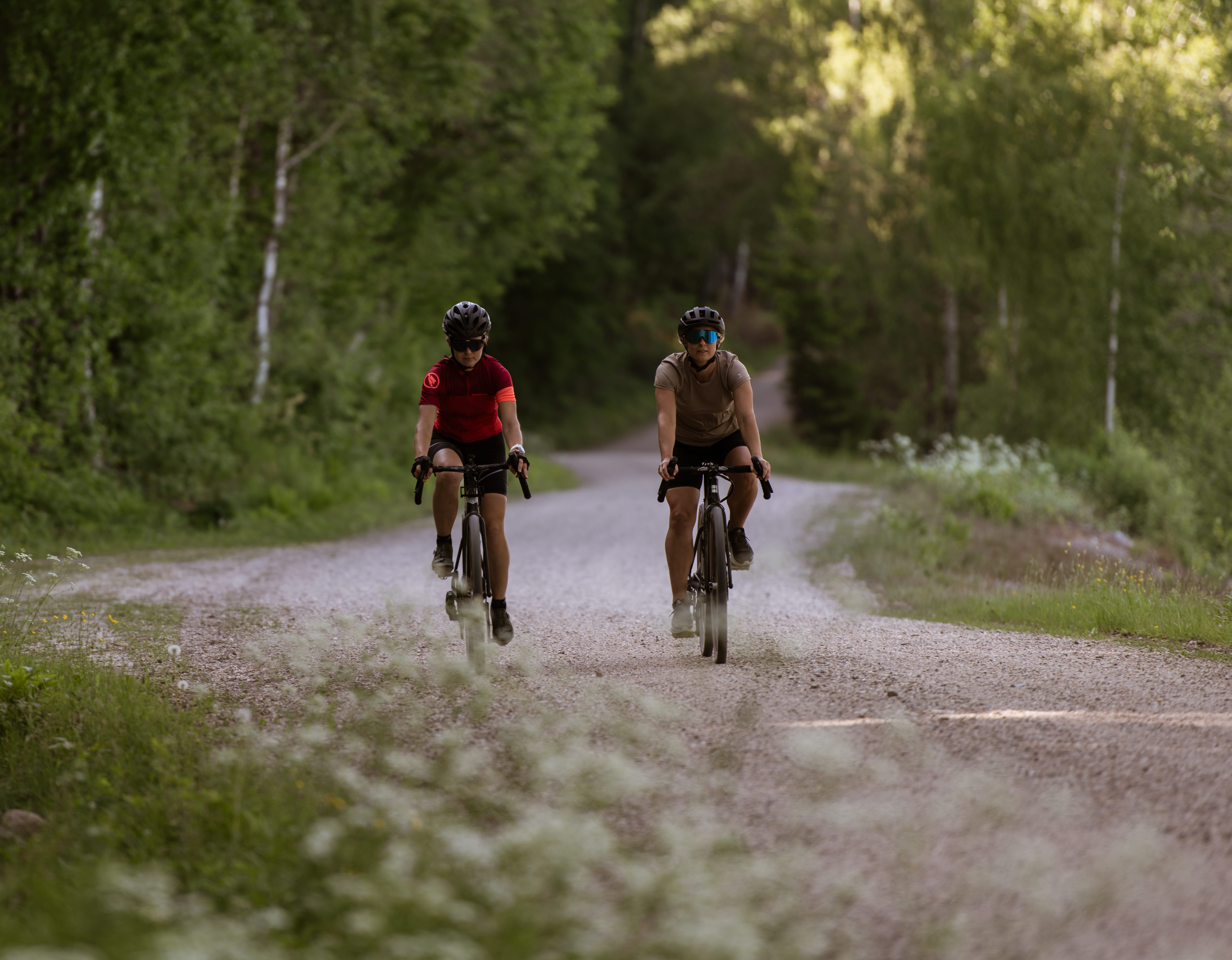 Cyklister på en grusväg i skogen.