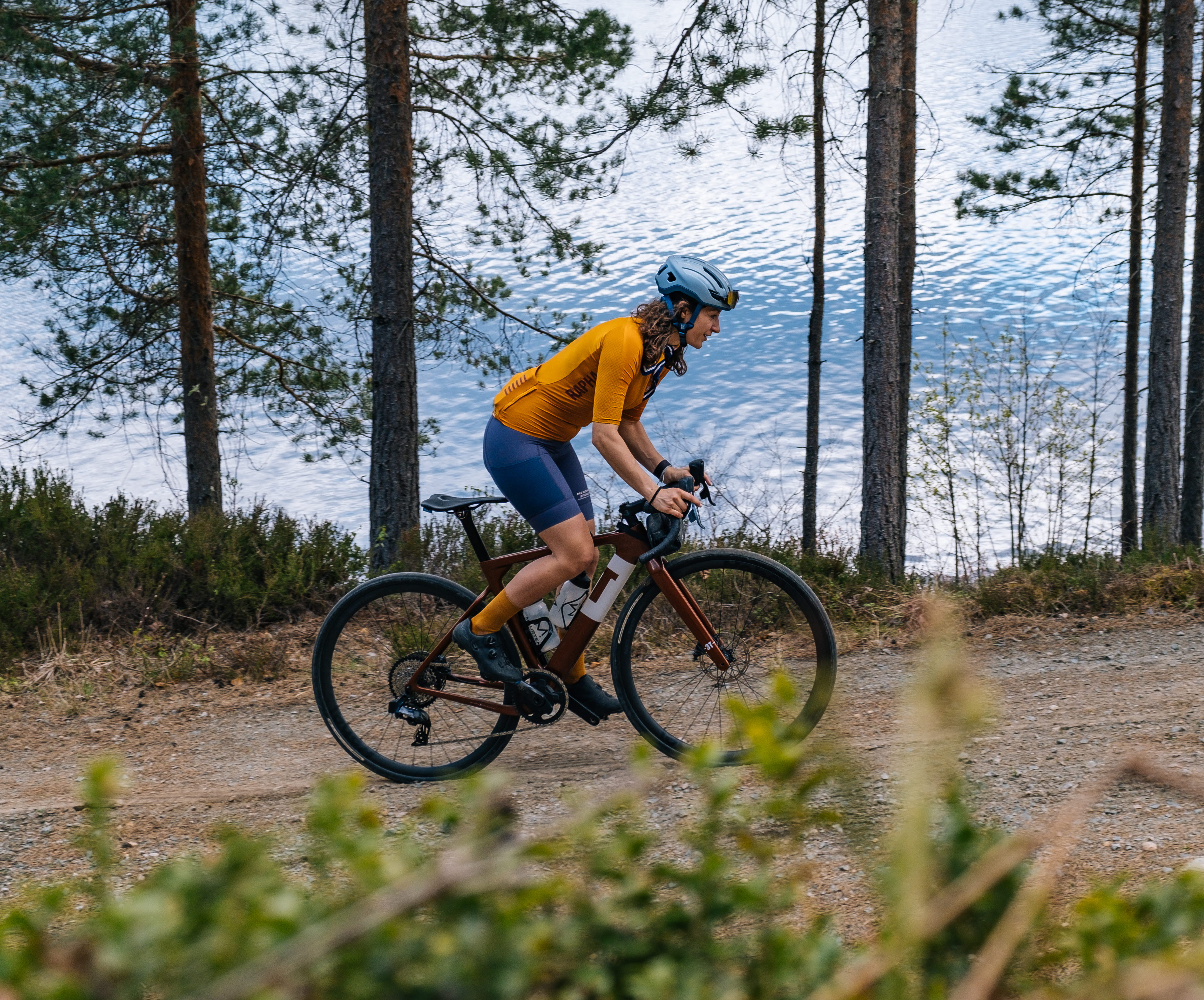 Kvinna cyklar på grusväg i Dalsland