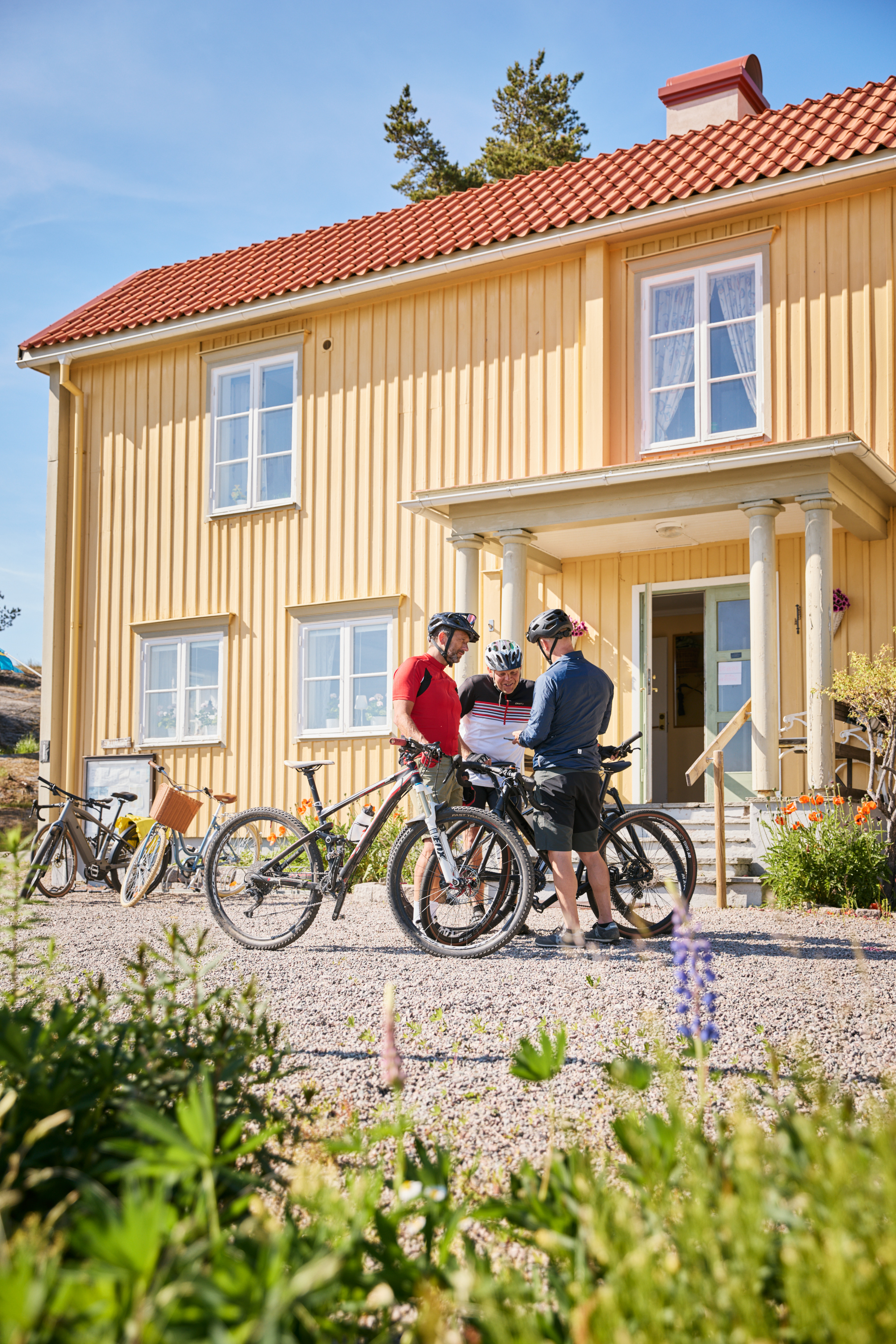 Grupp cyklister utanför ett vandrarhem.