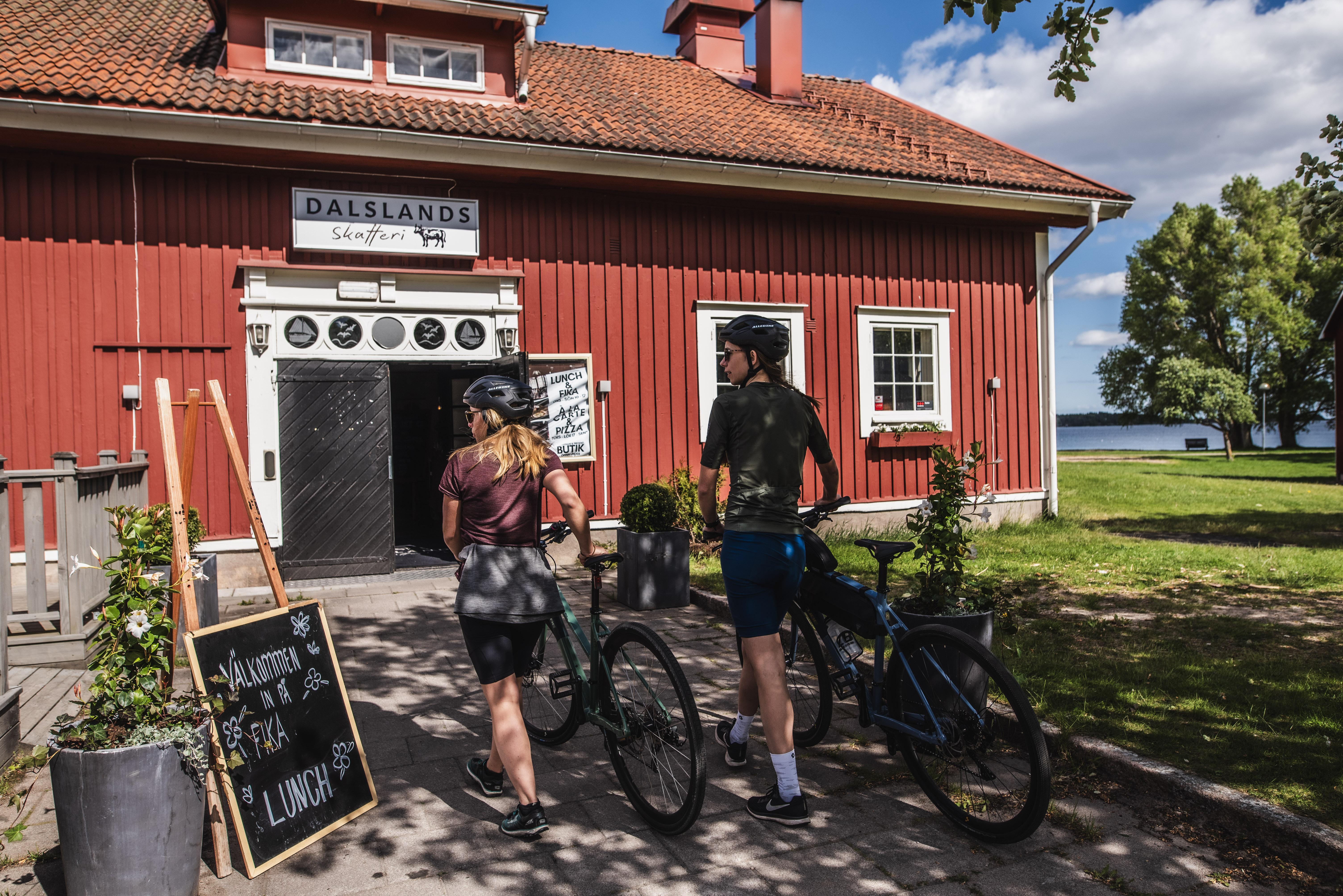 Två kvinnor leder sina cyklar.