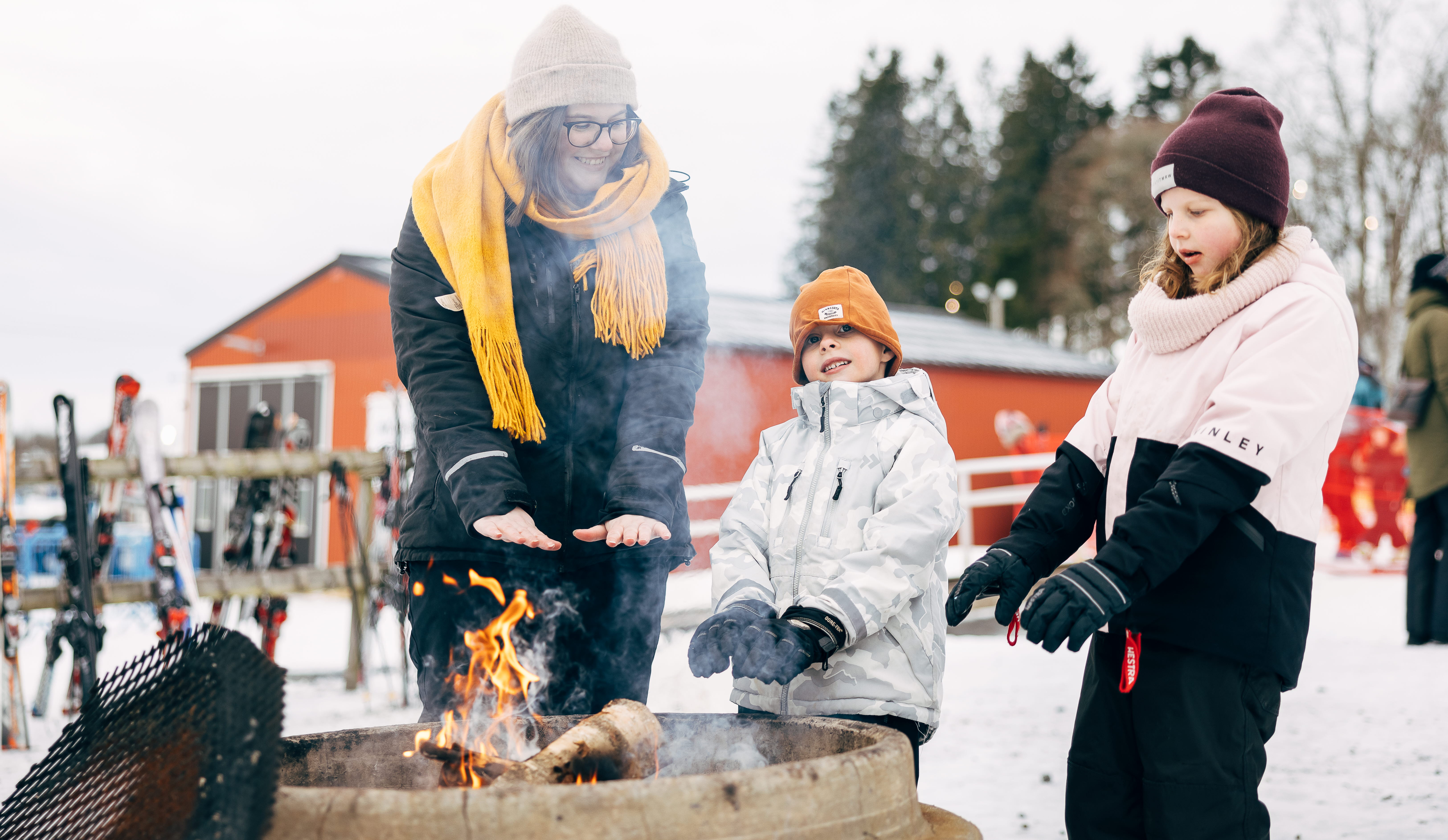 Familj tar en paus från skidåkning och äter en måltid.