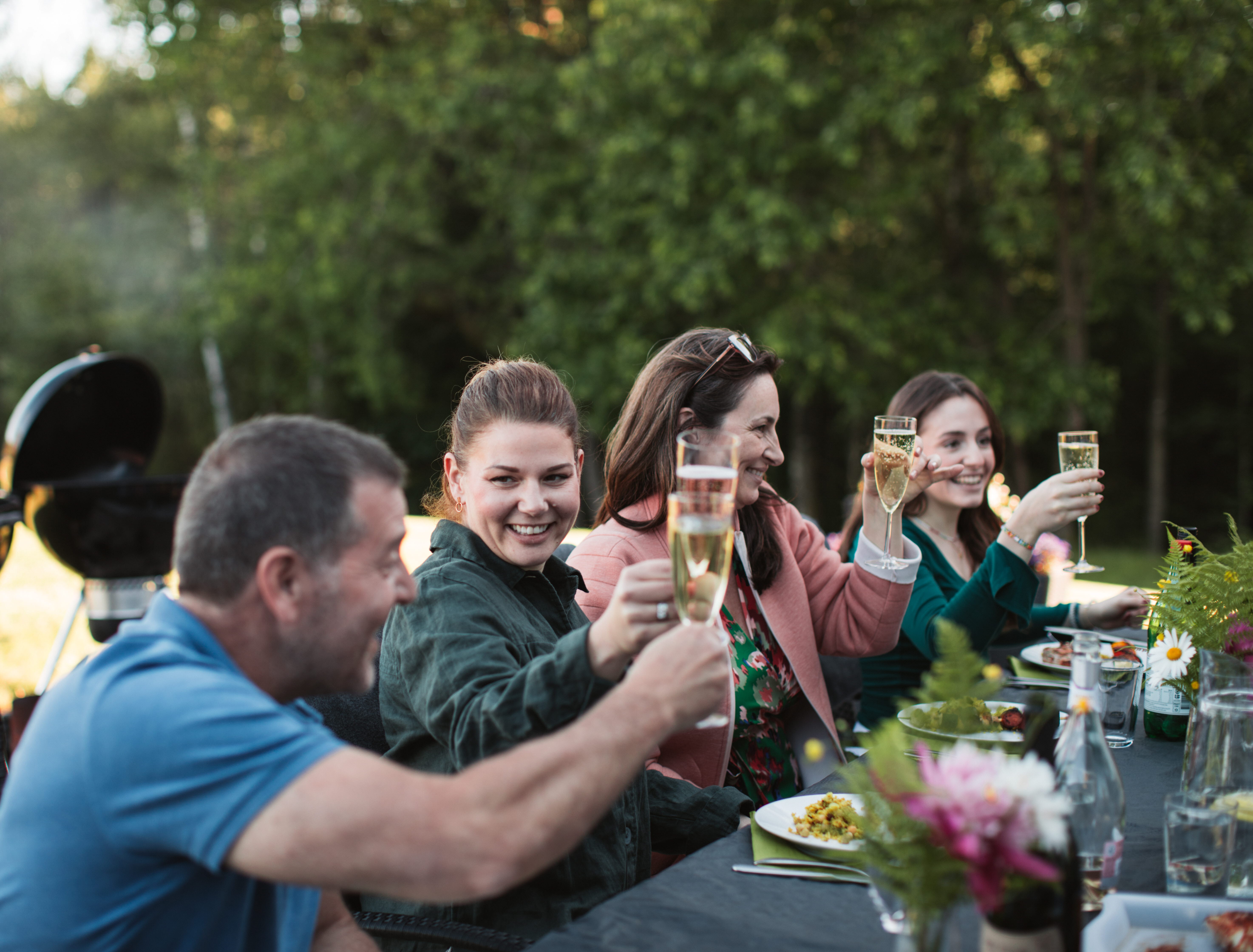 Grupp av människor umgås runt ett dukat bord.