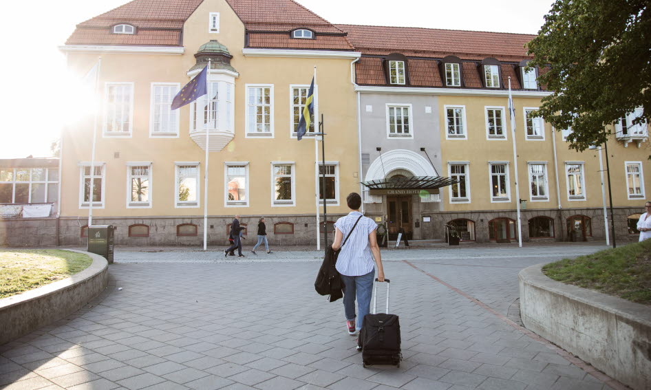 Woman walks towards hotel building.