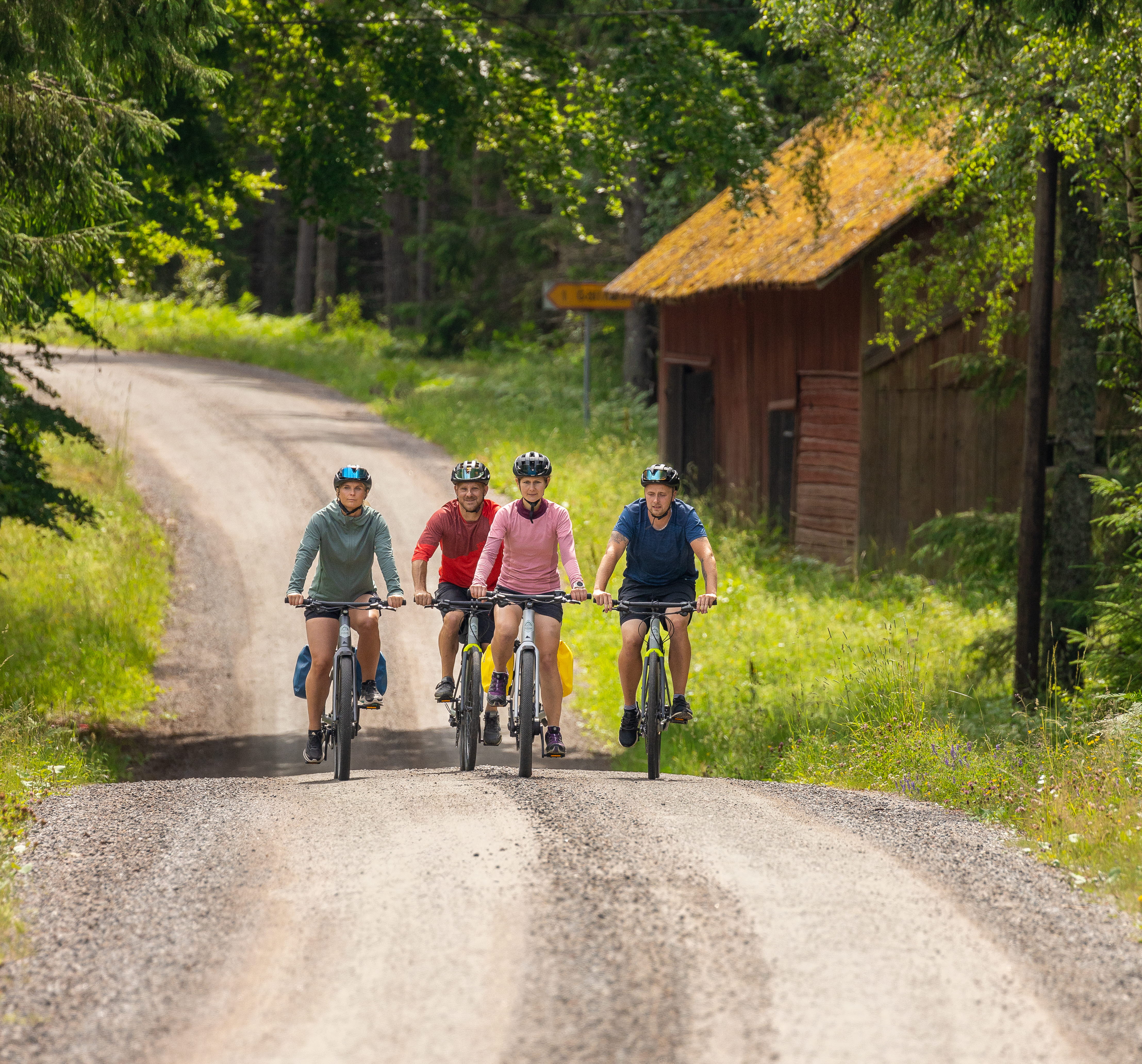 Cyklister på grusvägar i skogen.