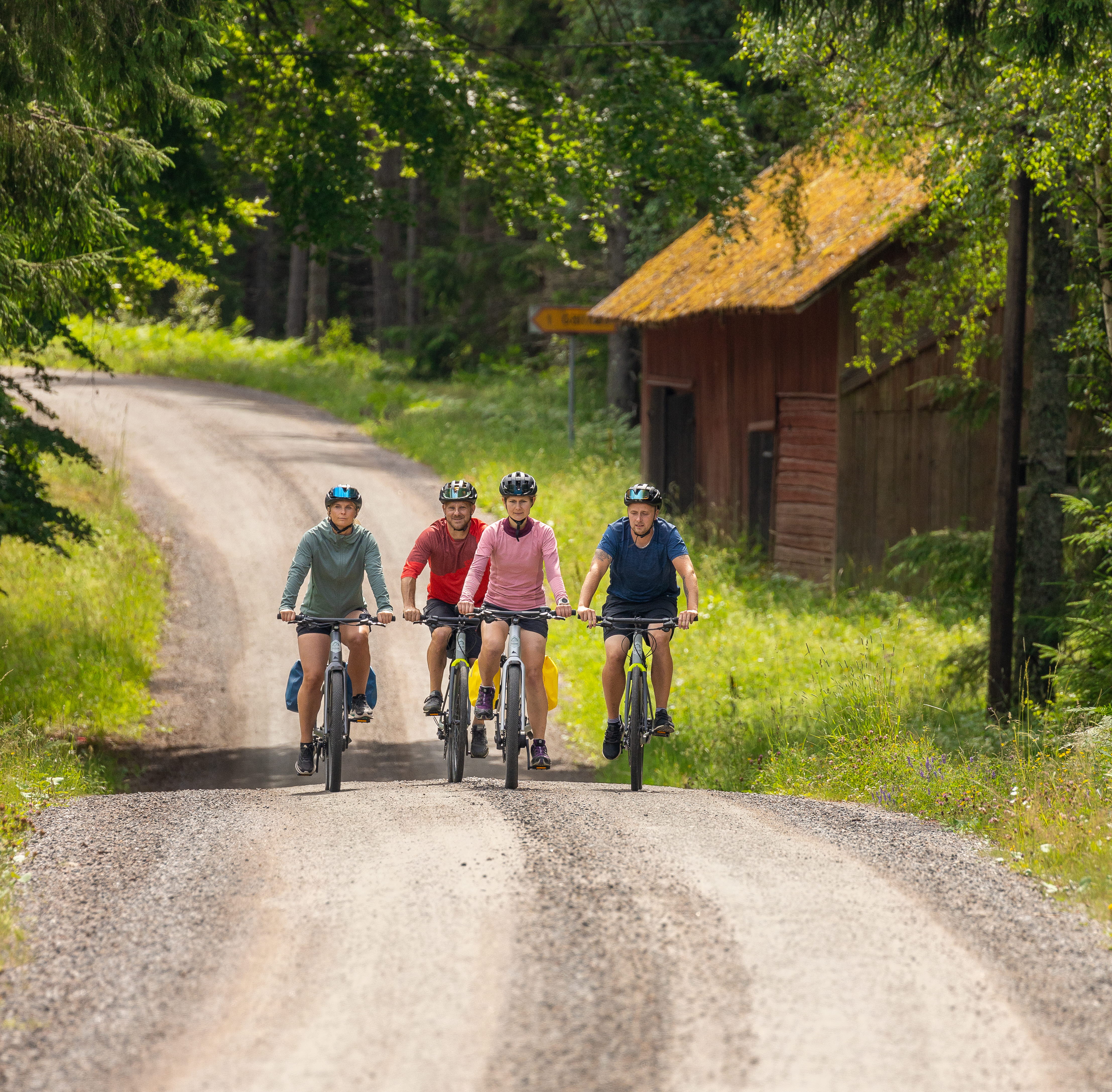 Cyklister på grusvägar i skogen.
