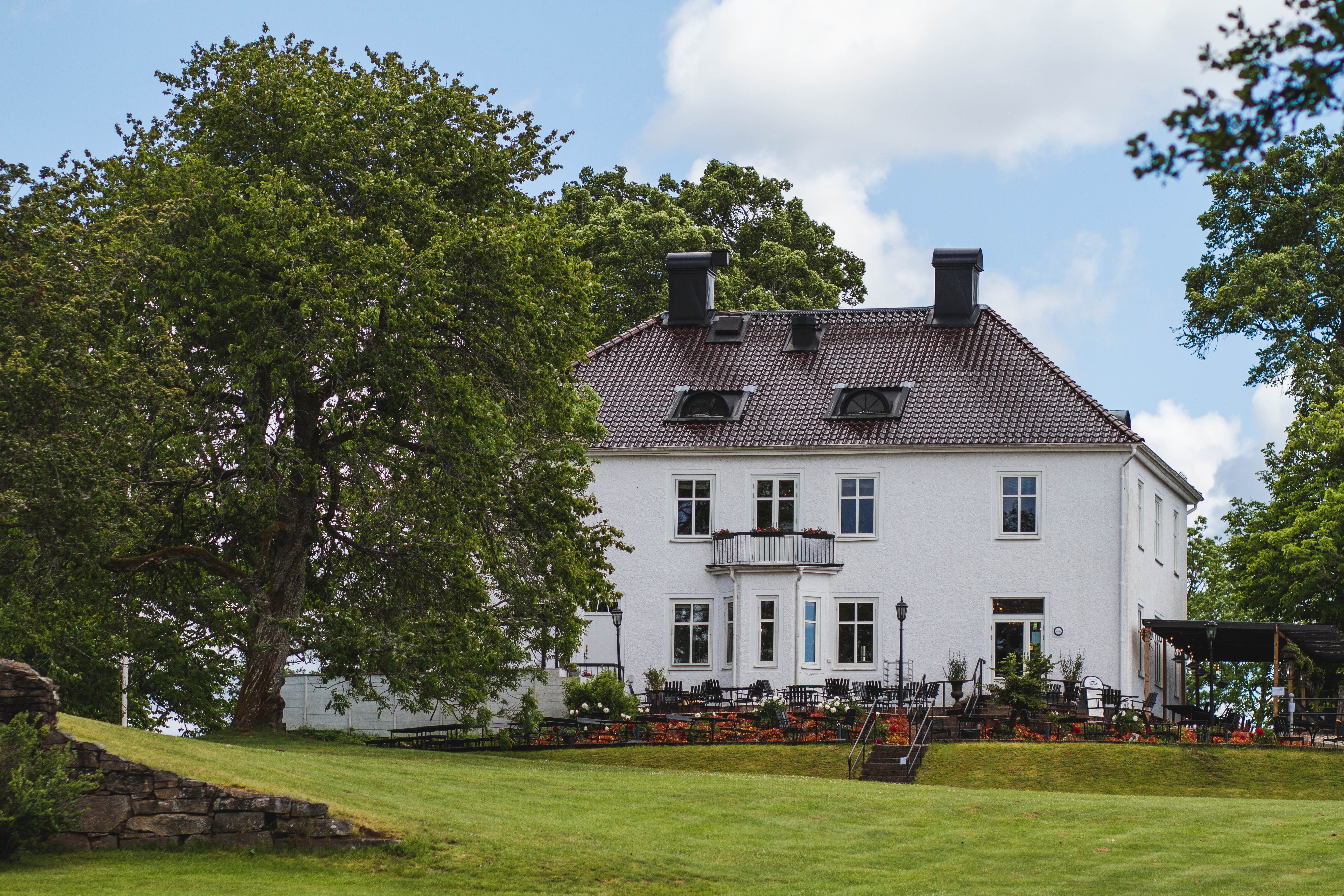 Herrgårdsbyggnad i grönska.