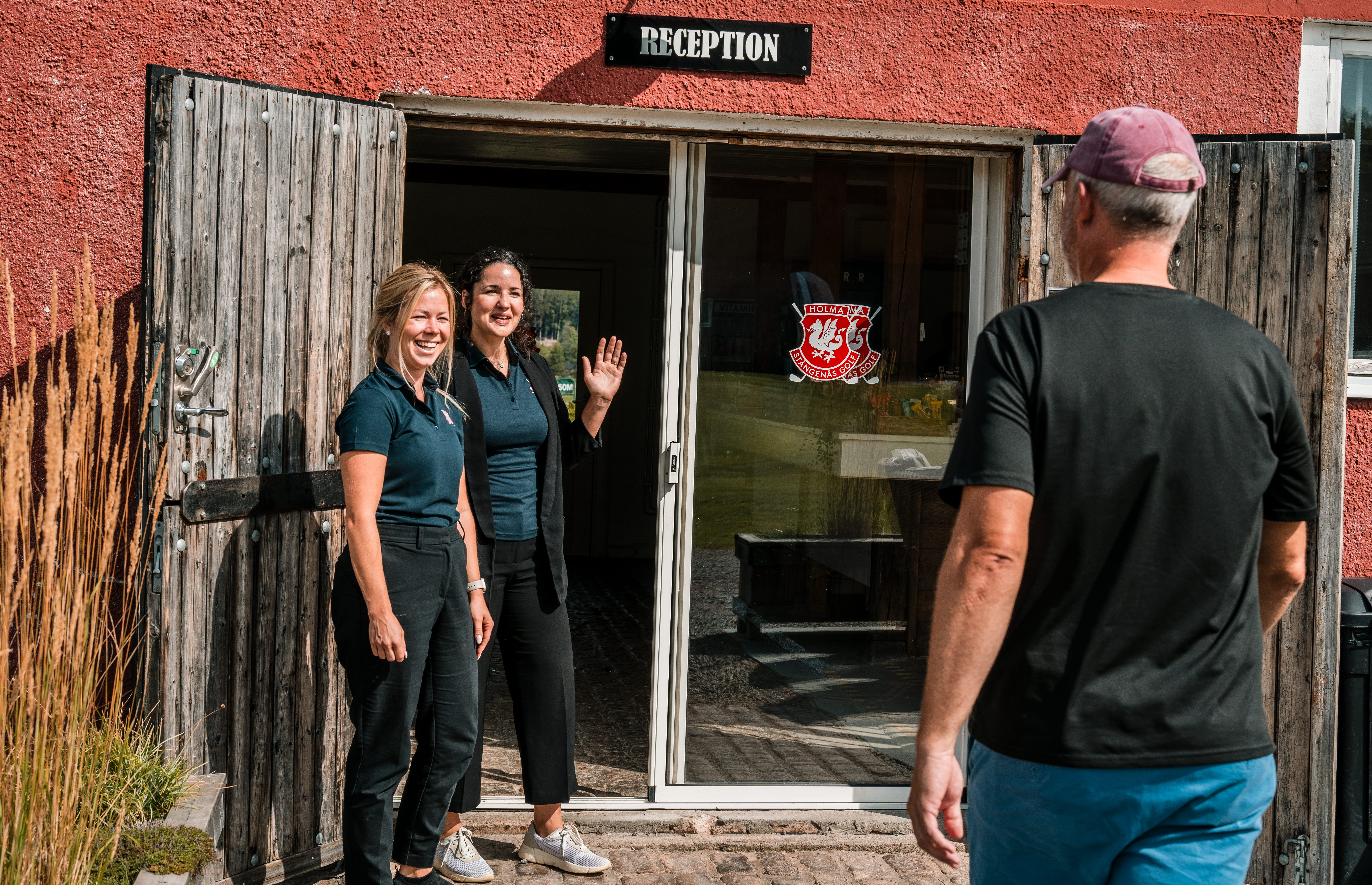 Två kvinnor står utanför en receptionsbyggnad.